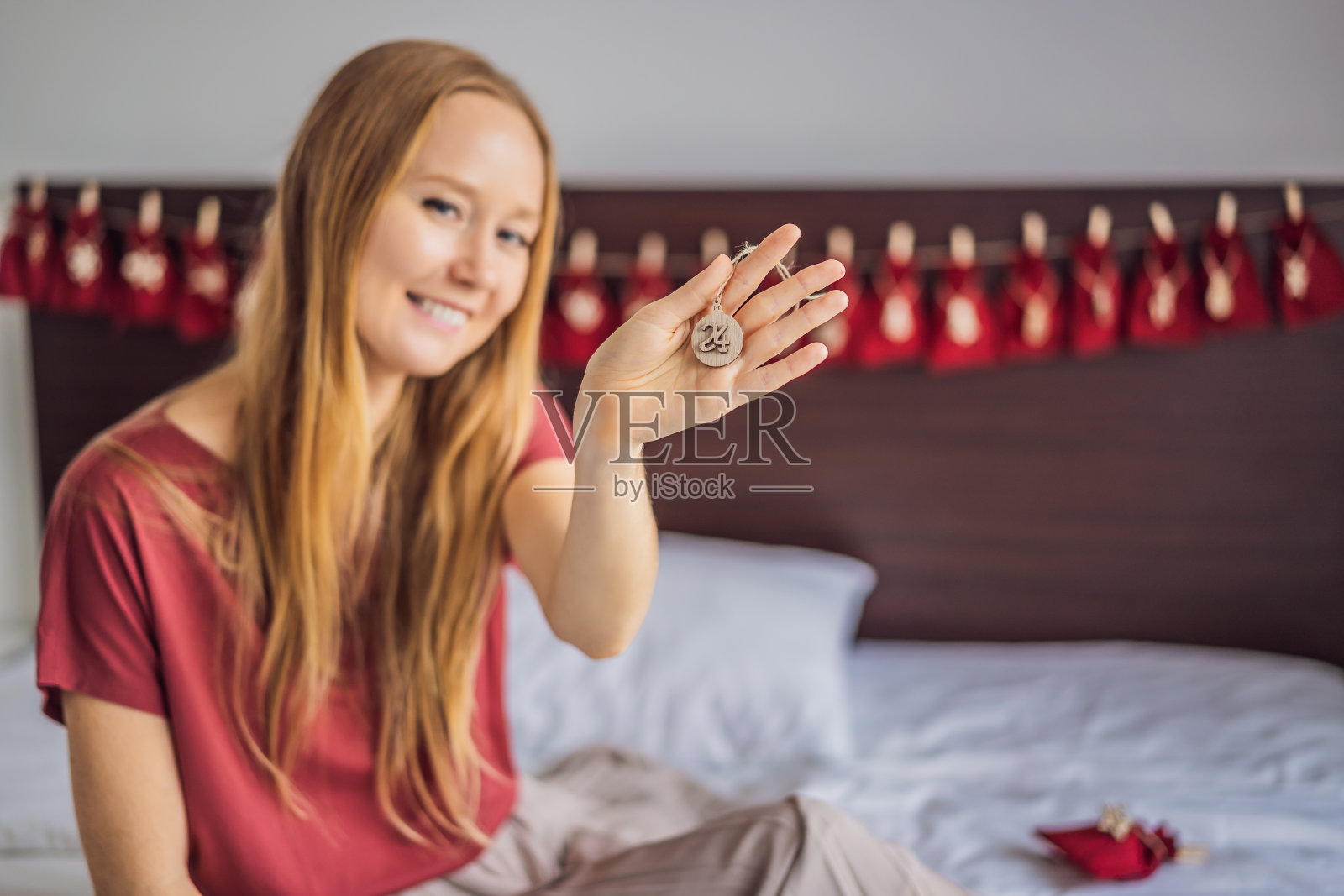 制作圣诞日历的妇女。绳子上的袋子照片摄影图片