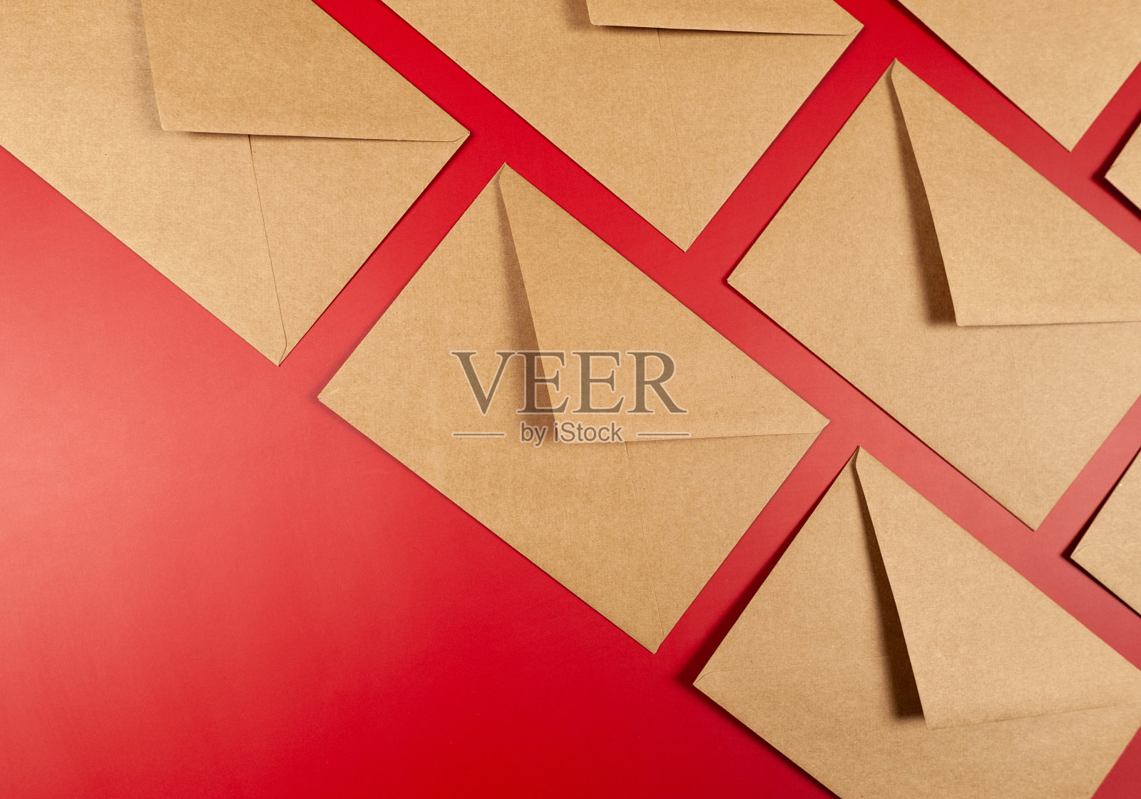 牛皮纸信封在红色背景的顶视图。照片摄影图片