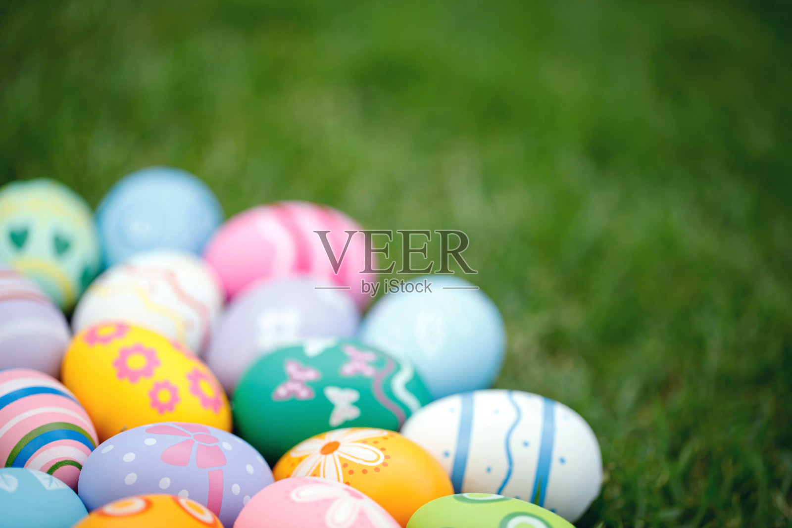 收集五颜六色的复活节彩蛋在绿色的草地上庆祝复活节或春天。照片摄影图片