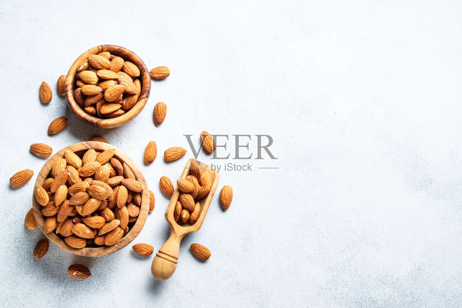 白色背景木碗里的杏仁。照片摄影图片