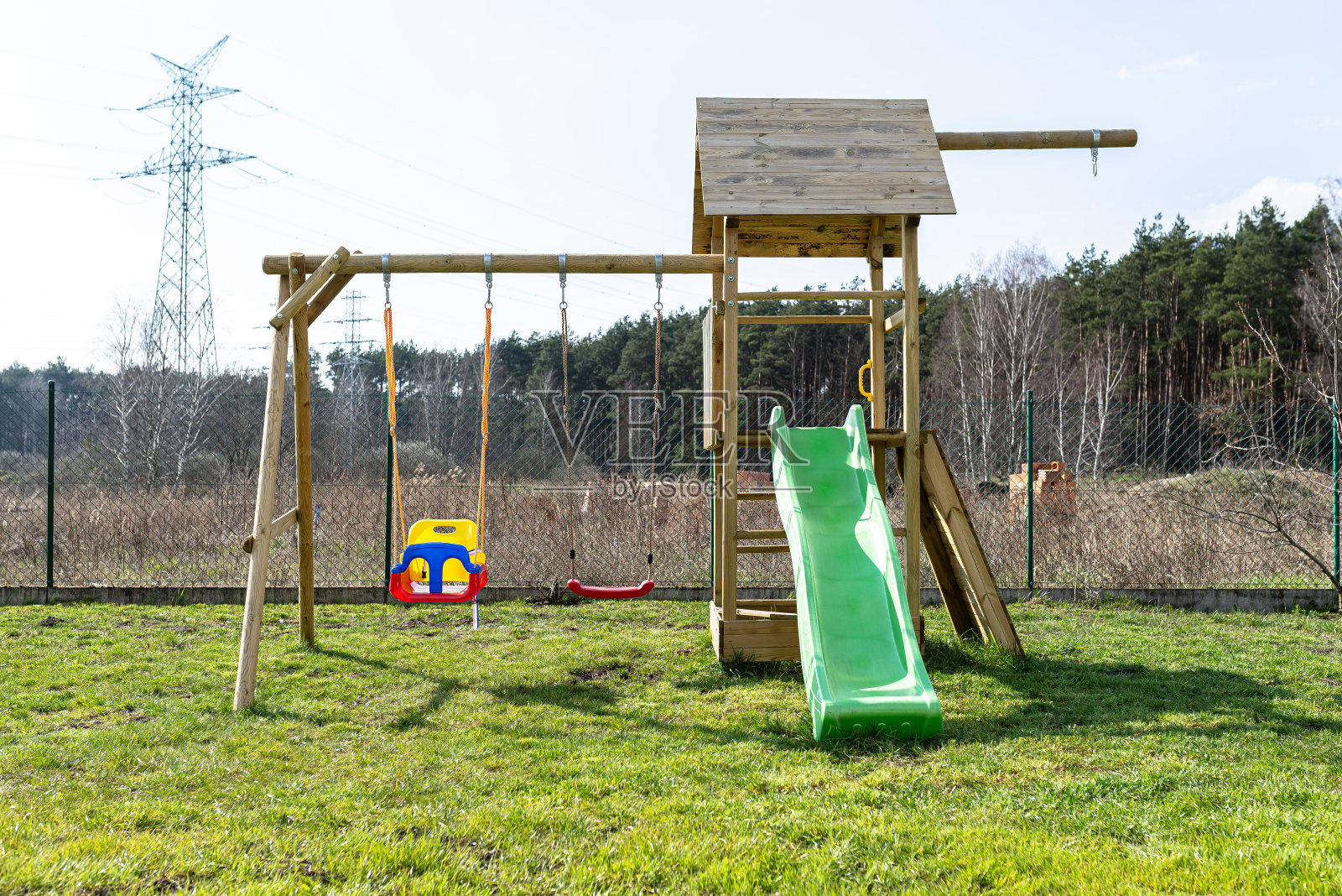 花园里的儿童游乐场是用未涂漆的木头建造的。照片摄影图片