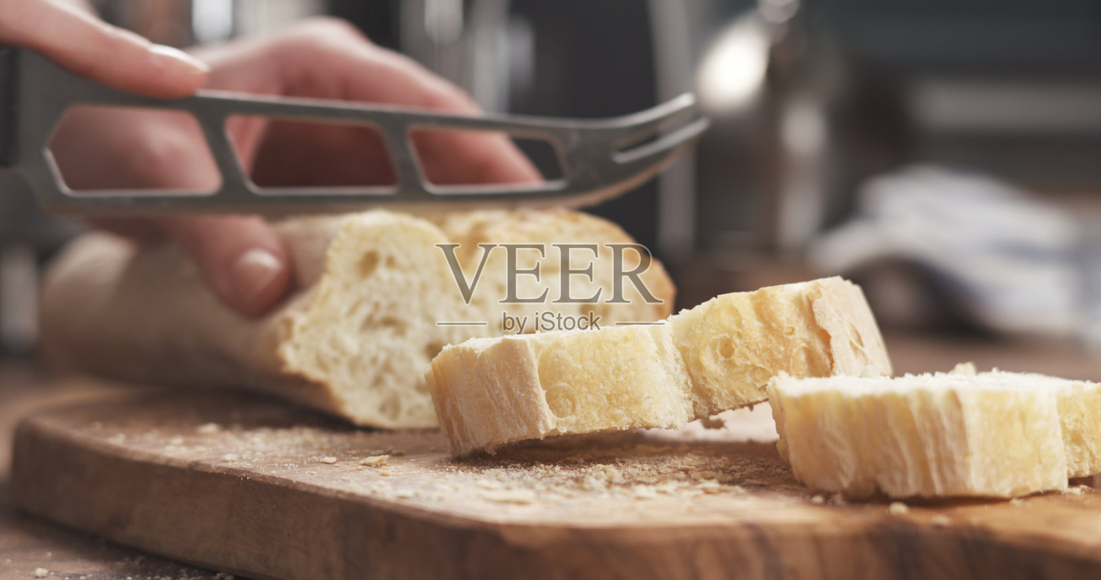 特写:在切菜板上切新鲜法棍照片摄影图片