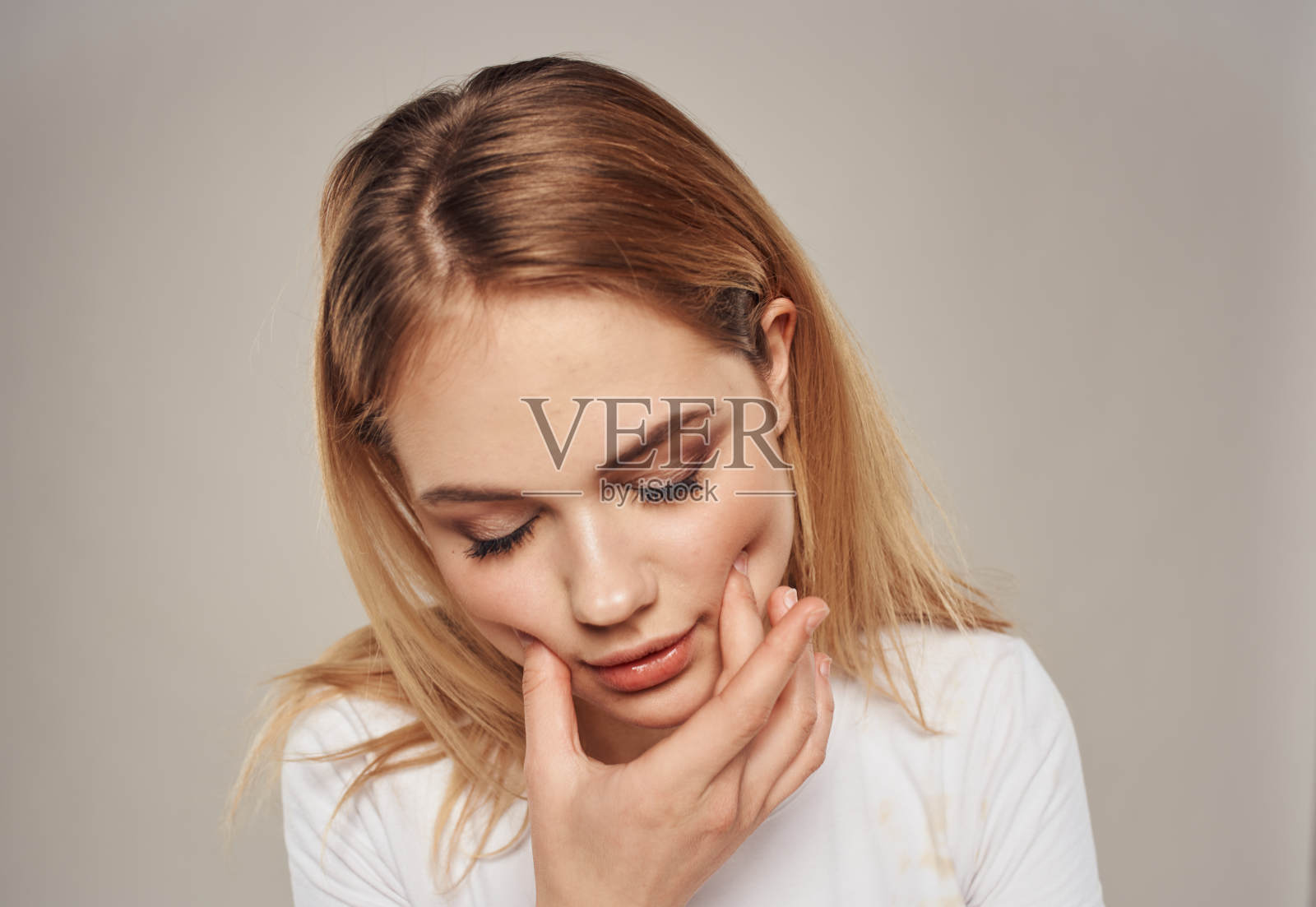 一个迷人的金发女人的肖像在一个灰色的背景特写照片摄影图片