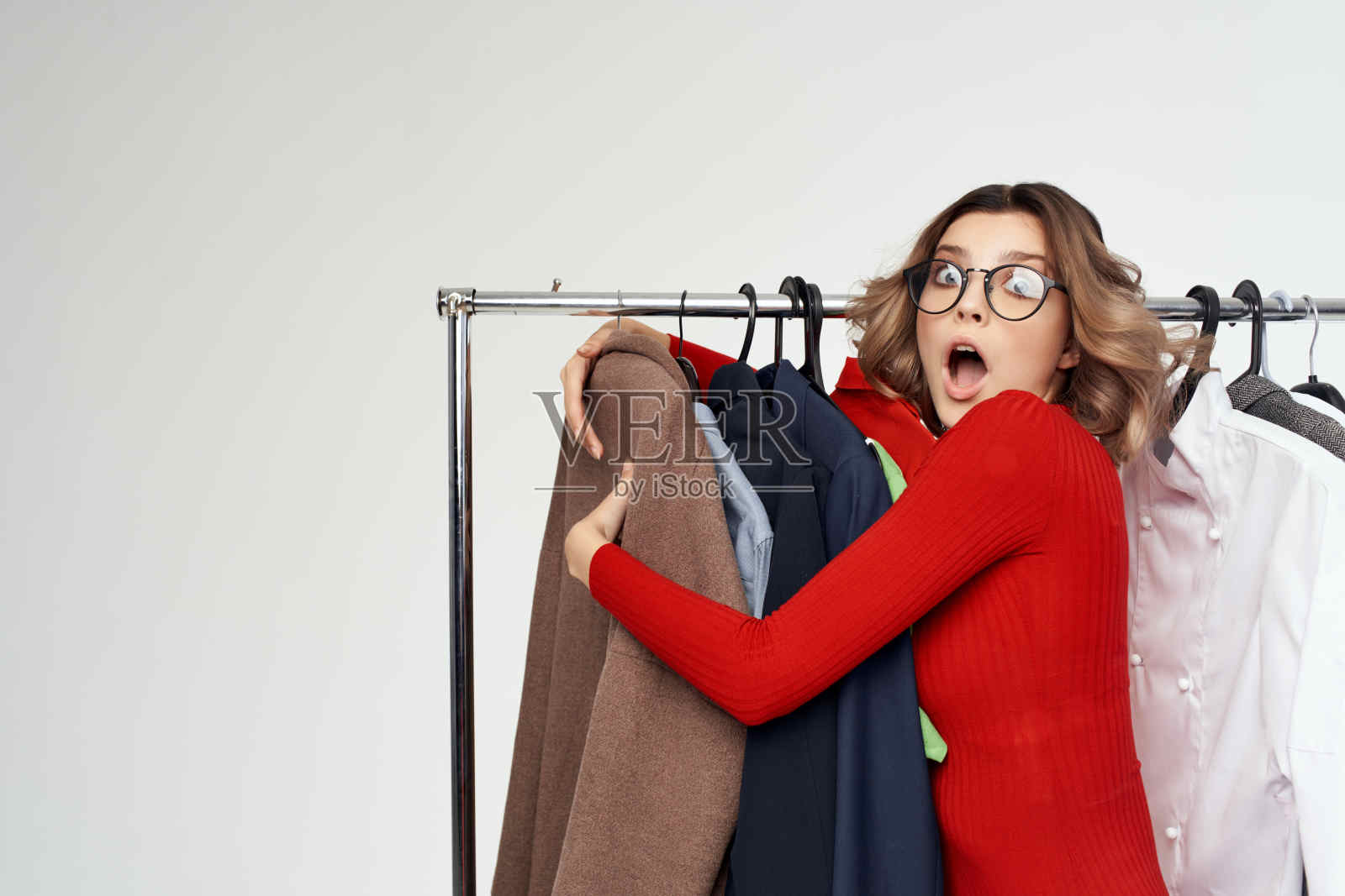 穿着红夹克的漂亮女人在衣橱附近零售情感照片摄影图片