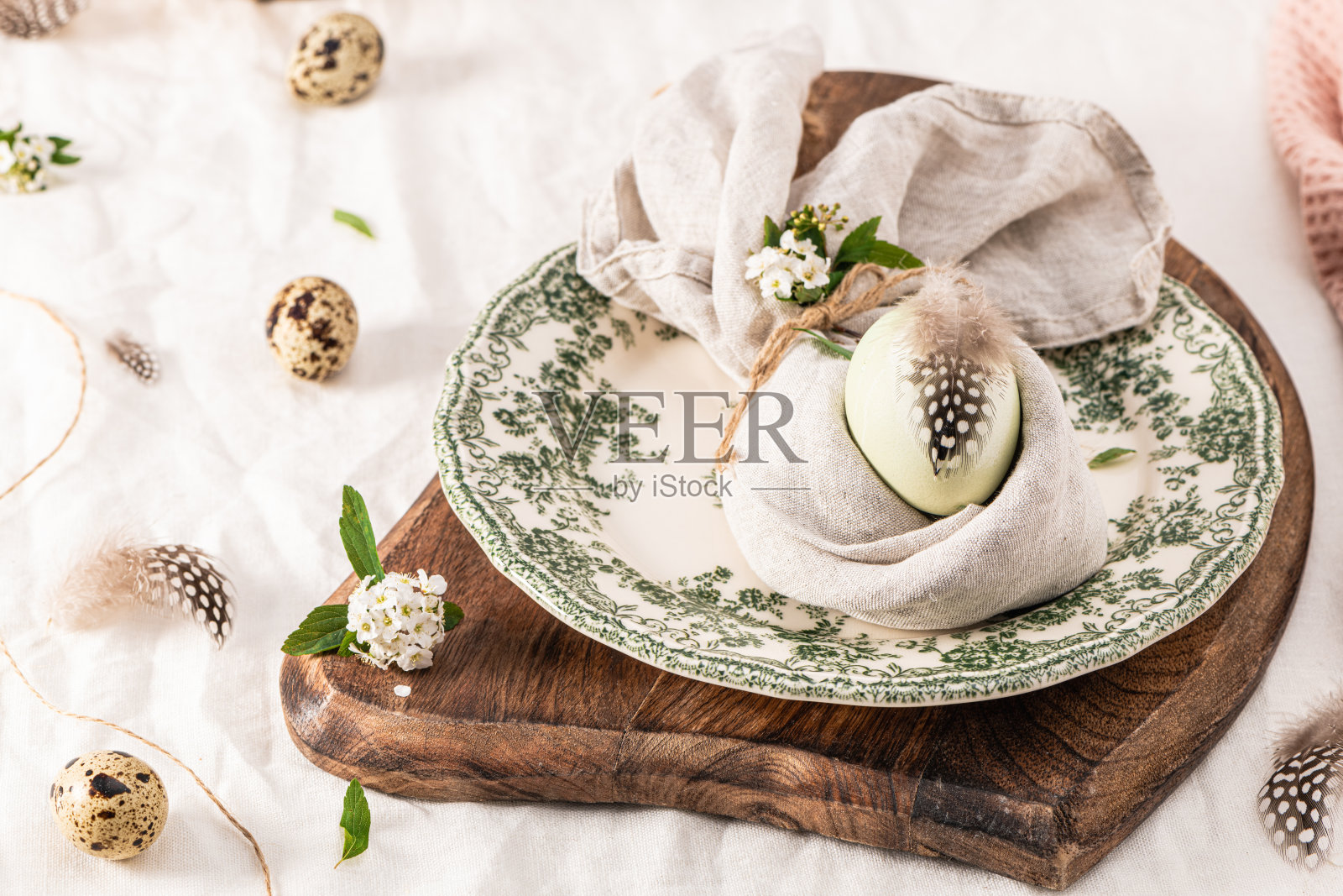 时尚的复活节早午餐餐桌设置与彩蛋在复活节兔子餐巾。照片摄影图片