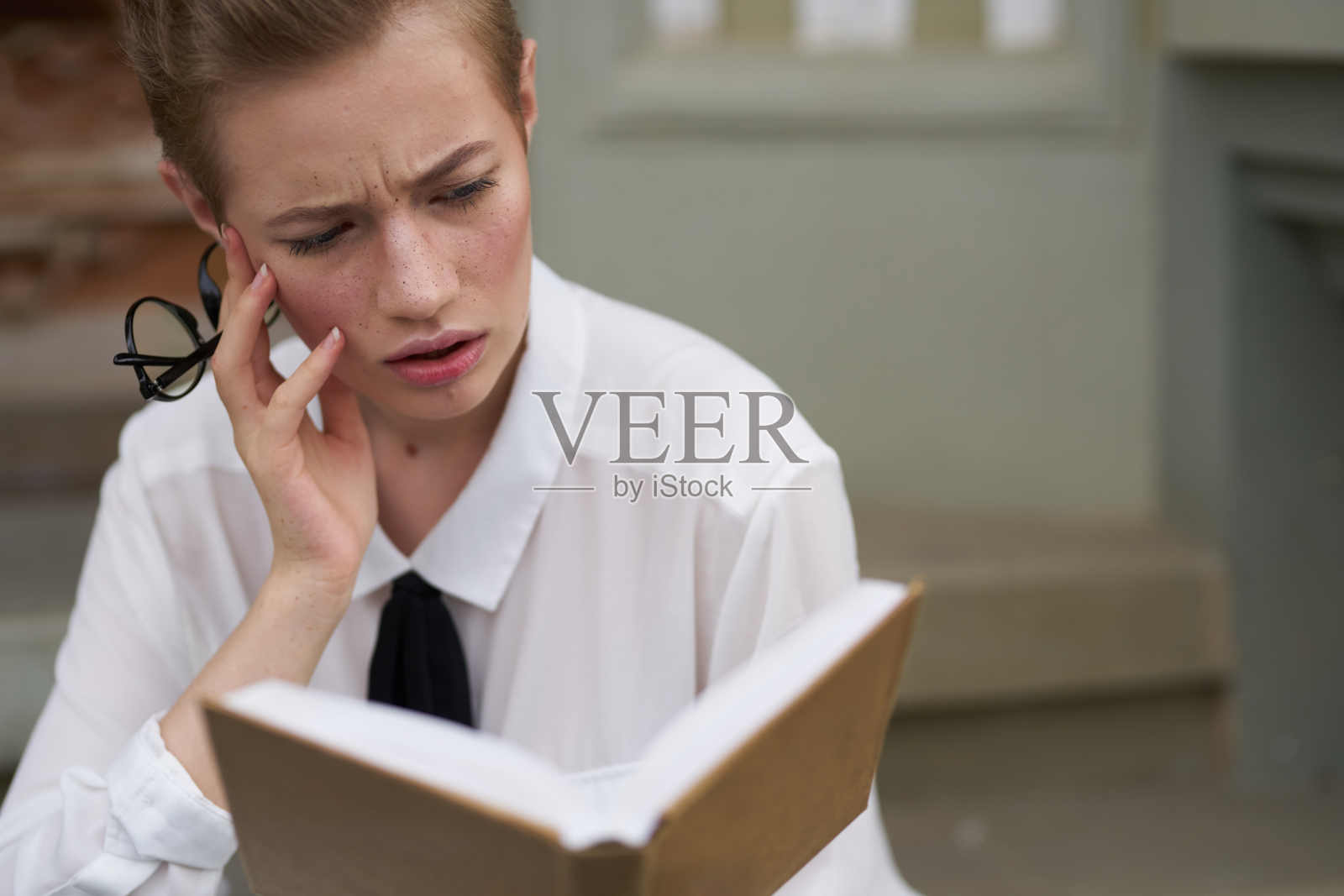 短发的女人手里拿着一本书在户外阅读生活方式照片摄影图片