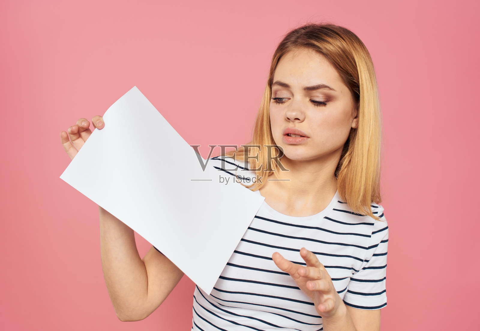 美丽的金发女人用一张白色的纸在粉红色的背景模型照片摄影图片