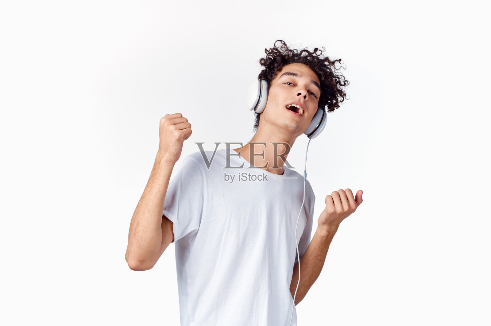 欢快的家伙戴着耳机听着音乐，用他的手做着手势照片摄影图片