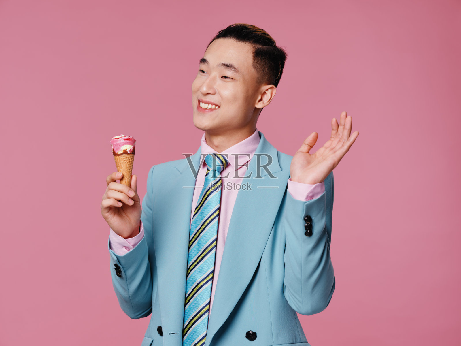 帅哥优雅的蓝色西装冰淇淋在手中喜悦的情绪孤立的背景照片摄影图片