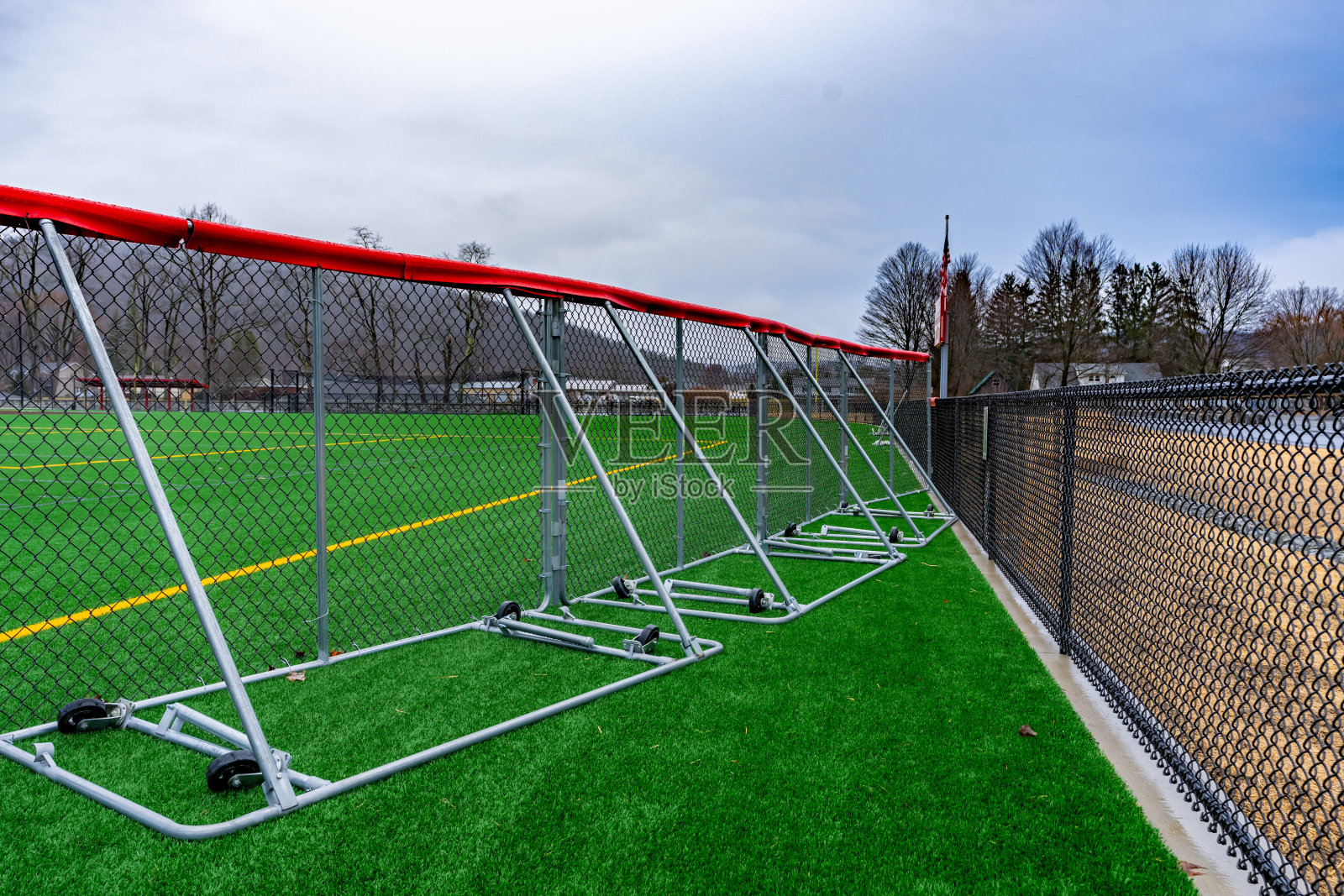 便携式垒球棒球外场围栏与红色围栏帽上的合成草皮足球照片摄影图片