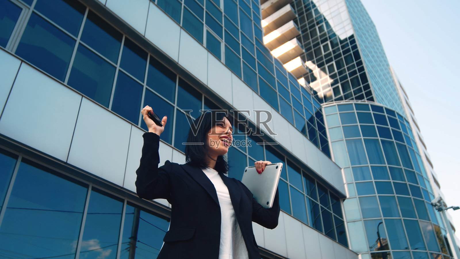 一个女商人站在城市街道上的特写。人力资源经理在现代化办公室附近的户外工作，经常打电话。照片摄影图片