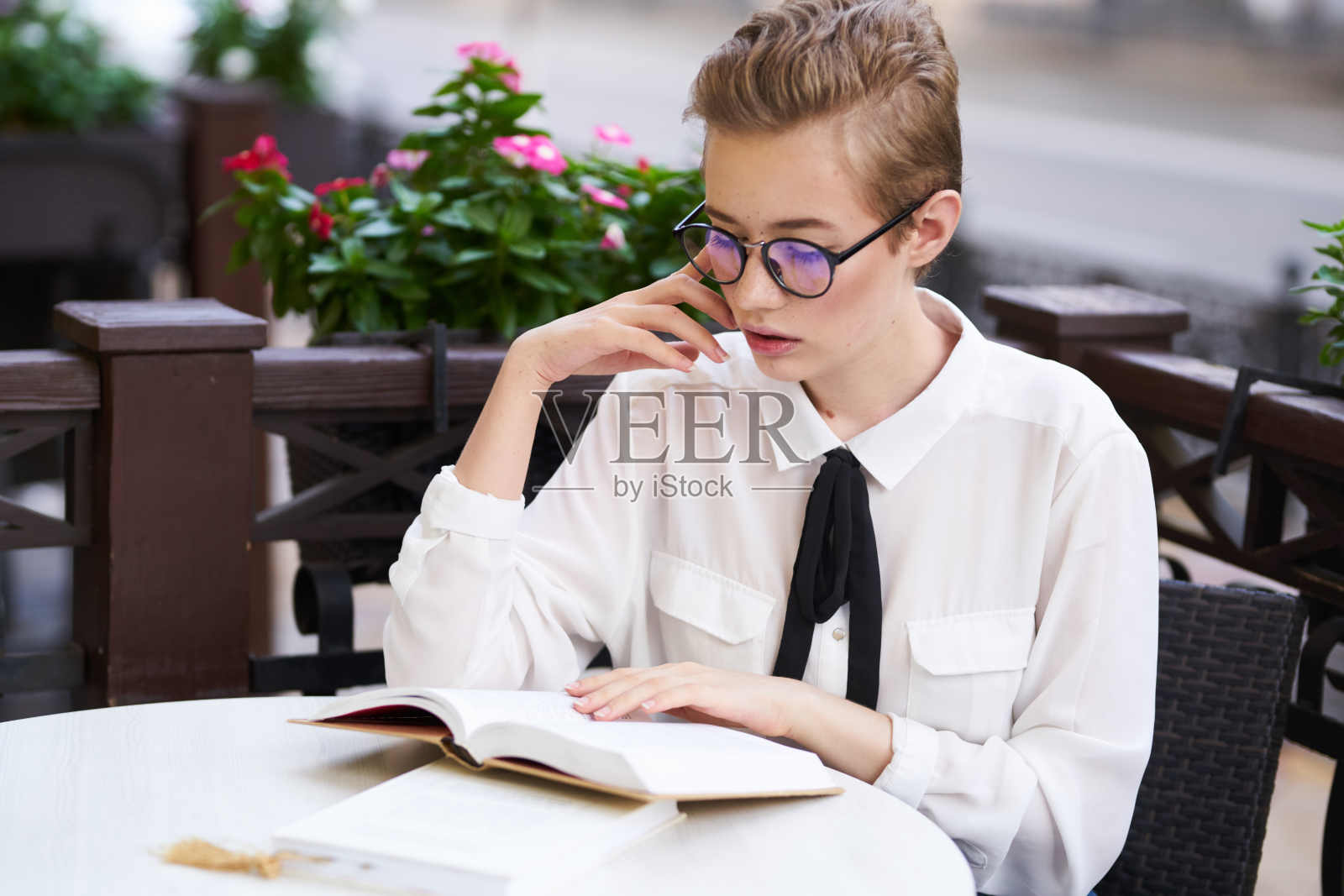 学生手里拿着一本书在户外休息，在镇上散步交流照片摄影图片