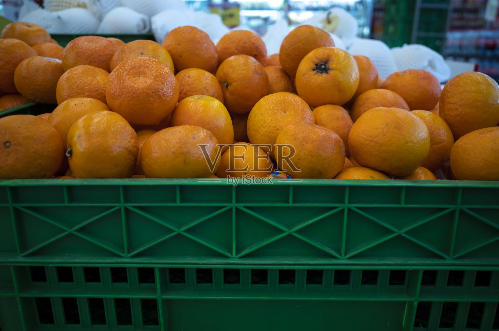超市里一堆熟透的橘子放在一个绿色的盒子里，浅焦照片摄影图片