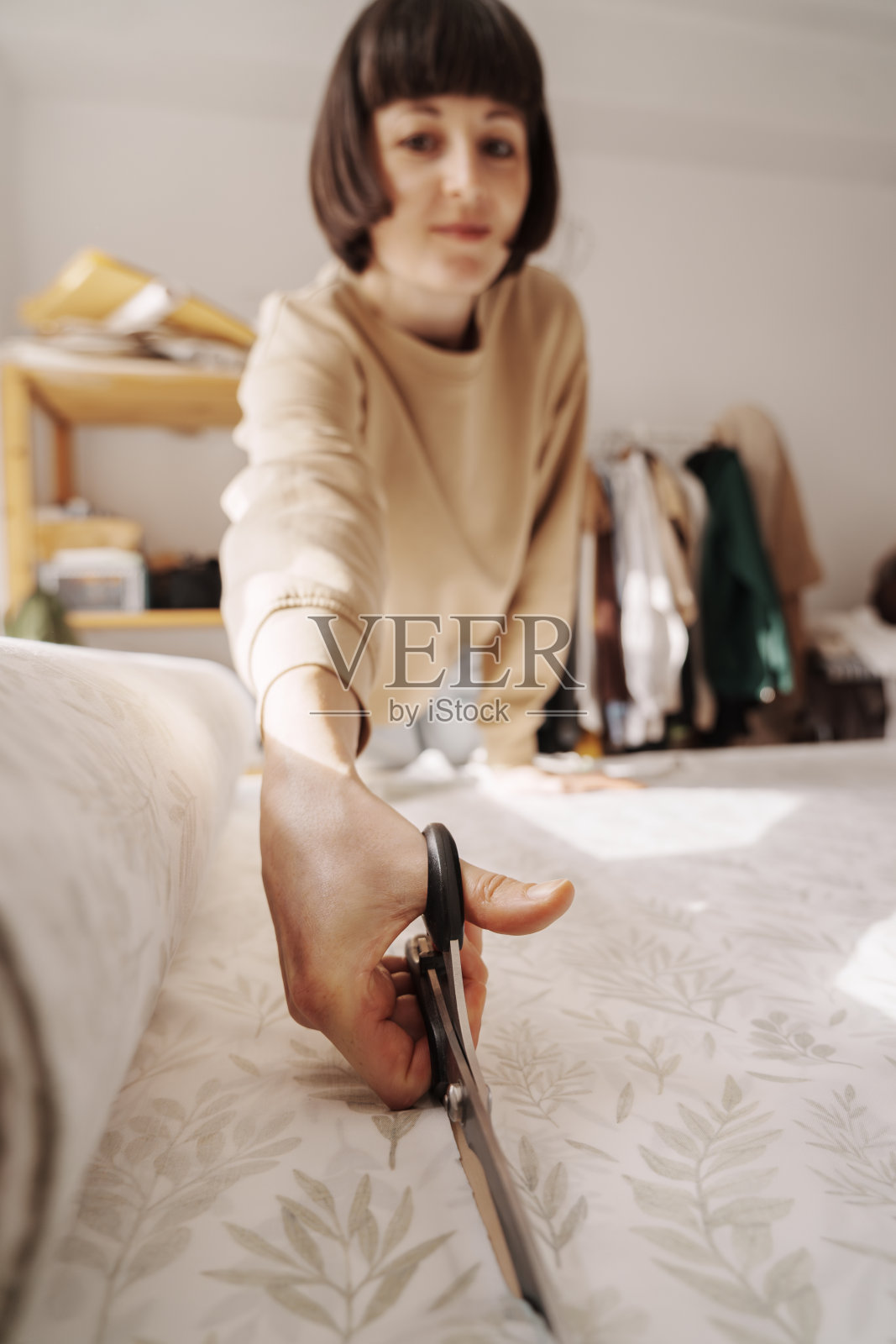 创意女裁缝在她的工作室裁剪布料照片摄影图片