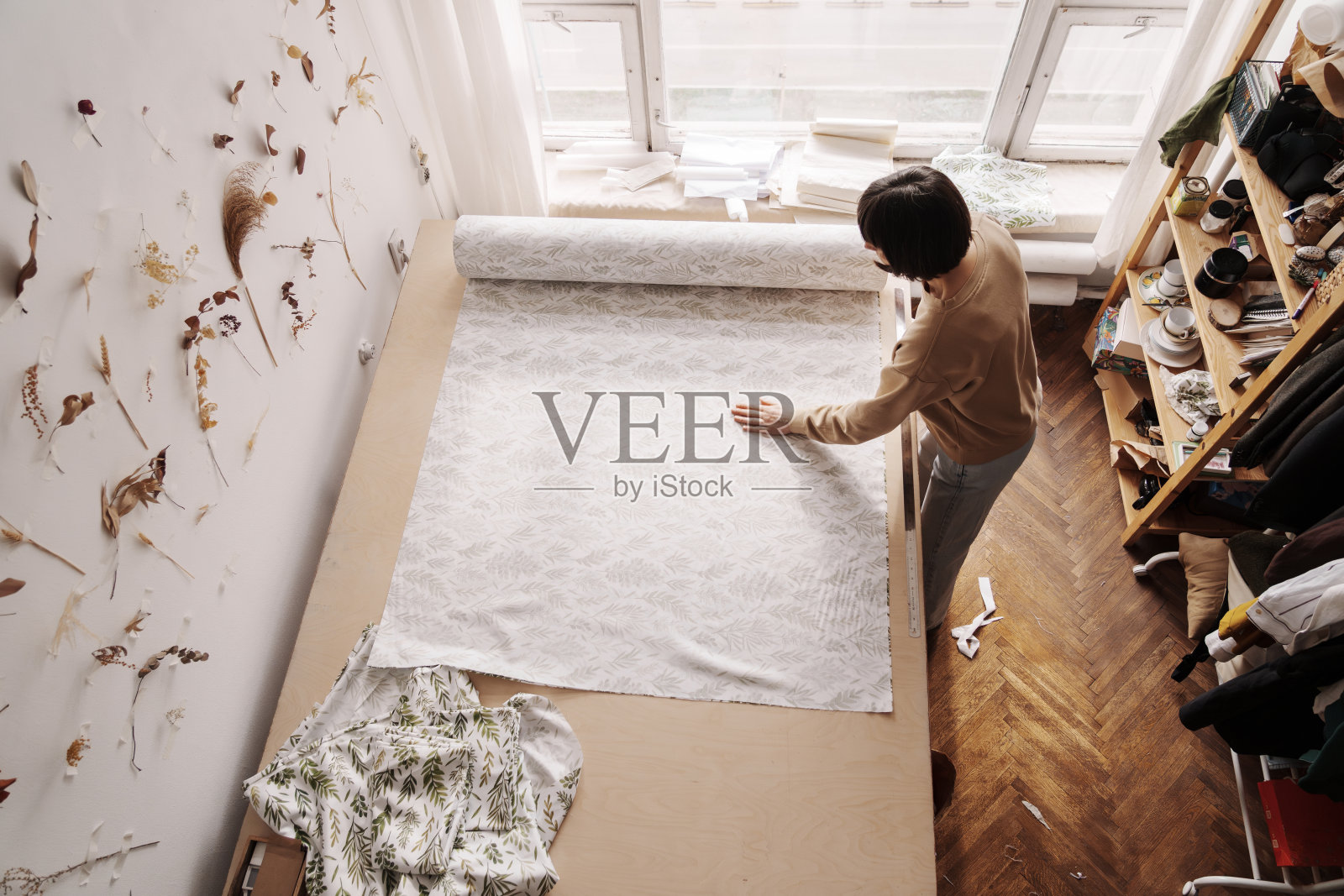 创意女裁缝在阳光明媚的车间里准备布料照片摄影图片