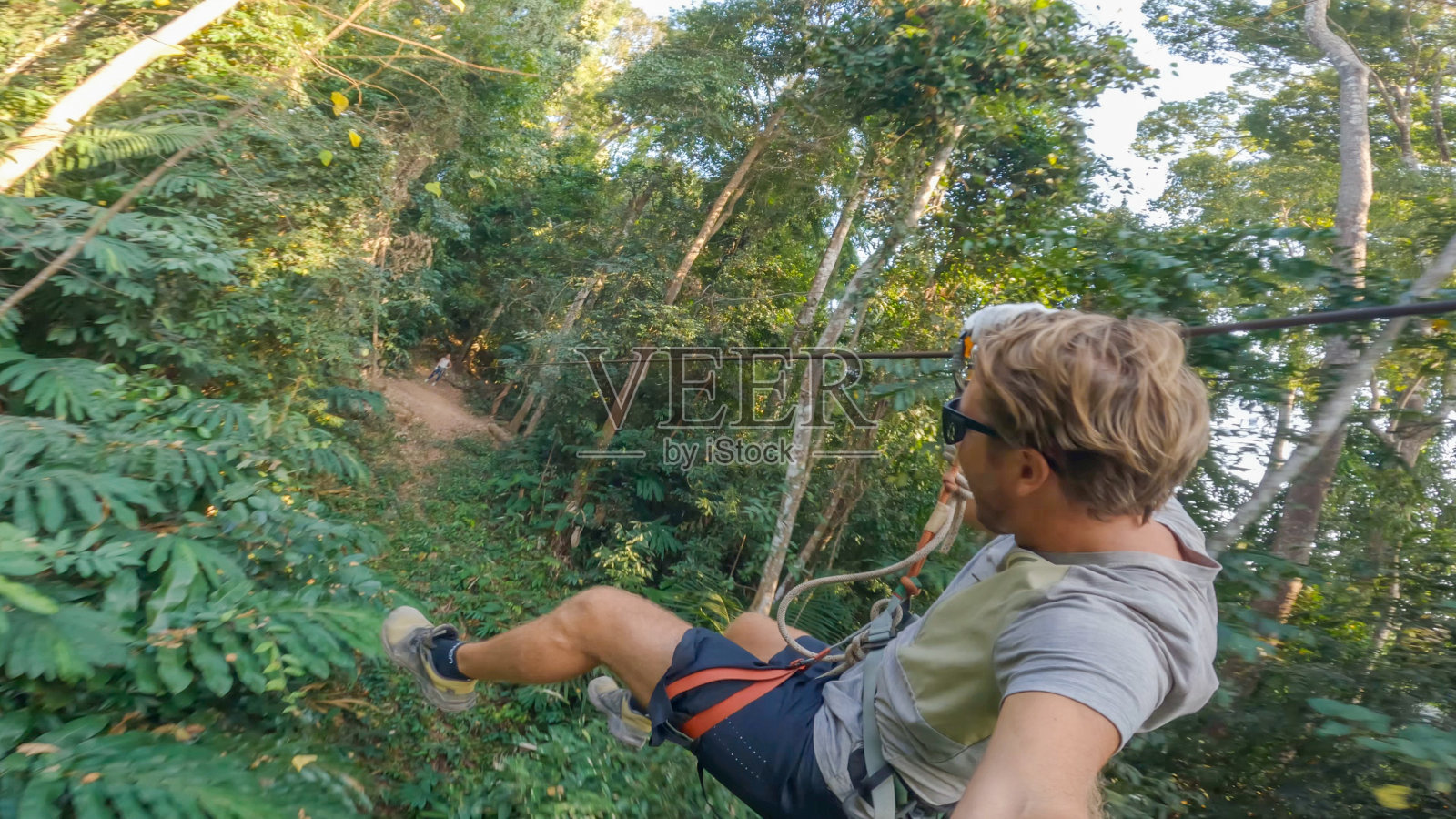 一个年轻人在老挝的丛林里滑索照片摄影图片