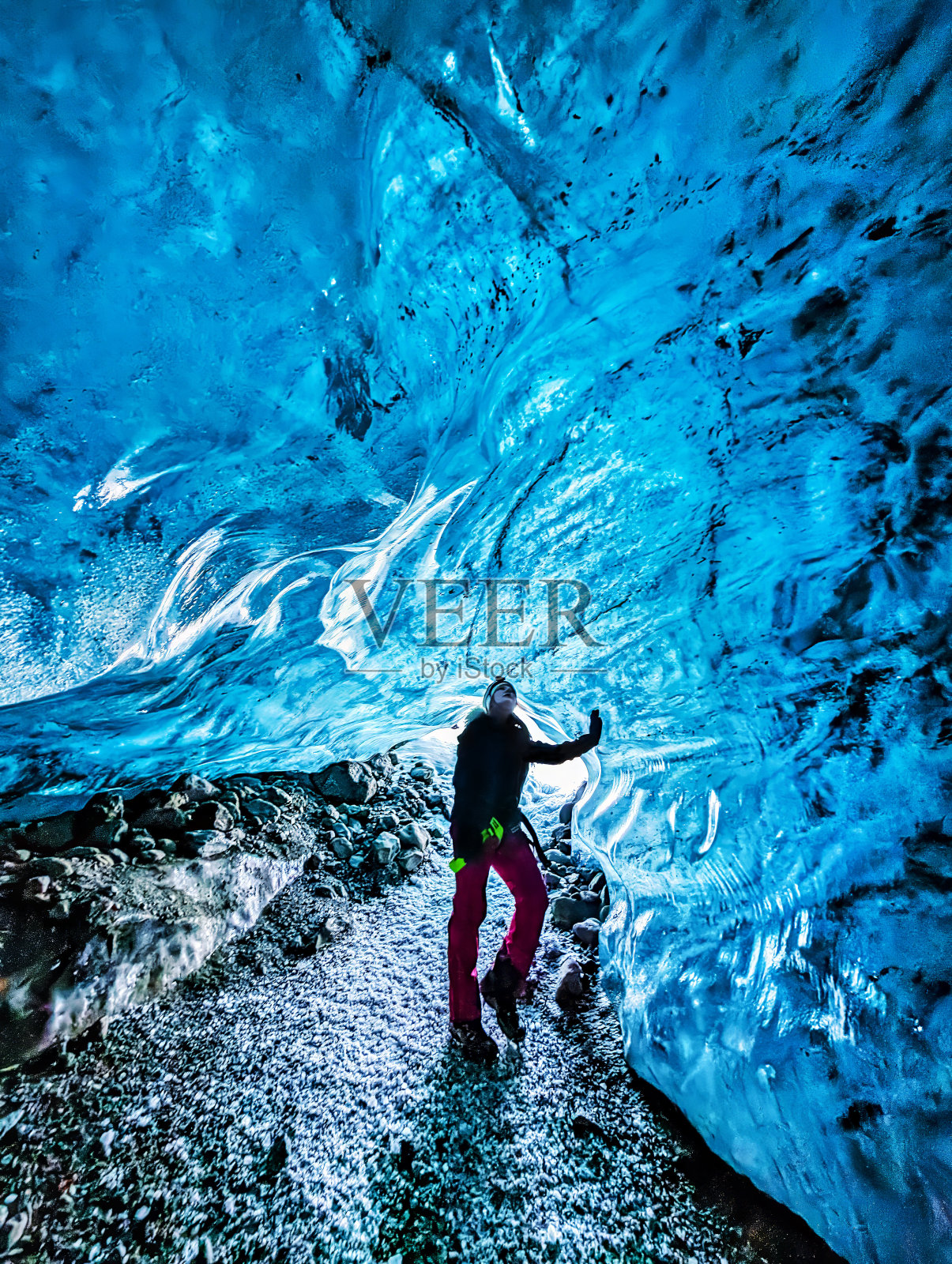 一名妇女在冰岛东南部瓦特纳冰川冰洞的开幕式上照片摄影图片