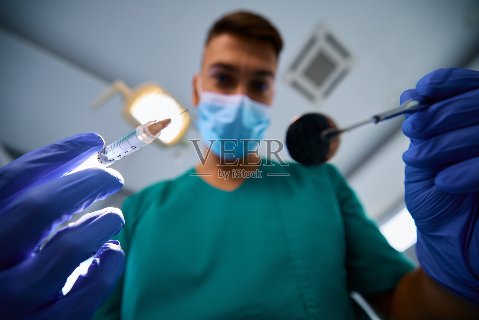 牙医在牙科手术中使用麻醉剂的近照。照片摄影图片