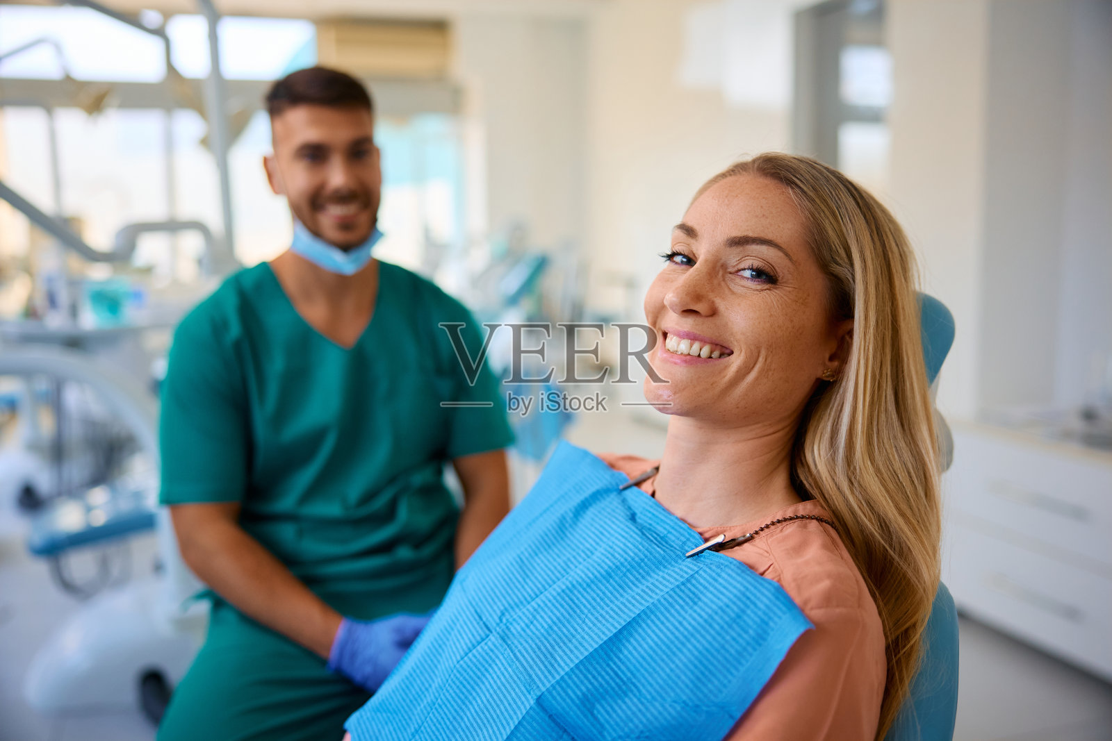 快乐的女人在看牙医时看着镜头。照片摄影图片