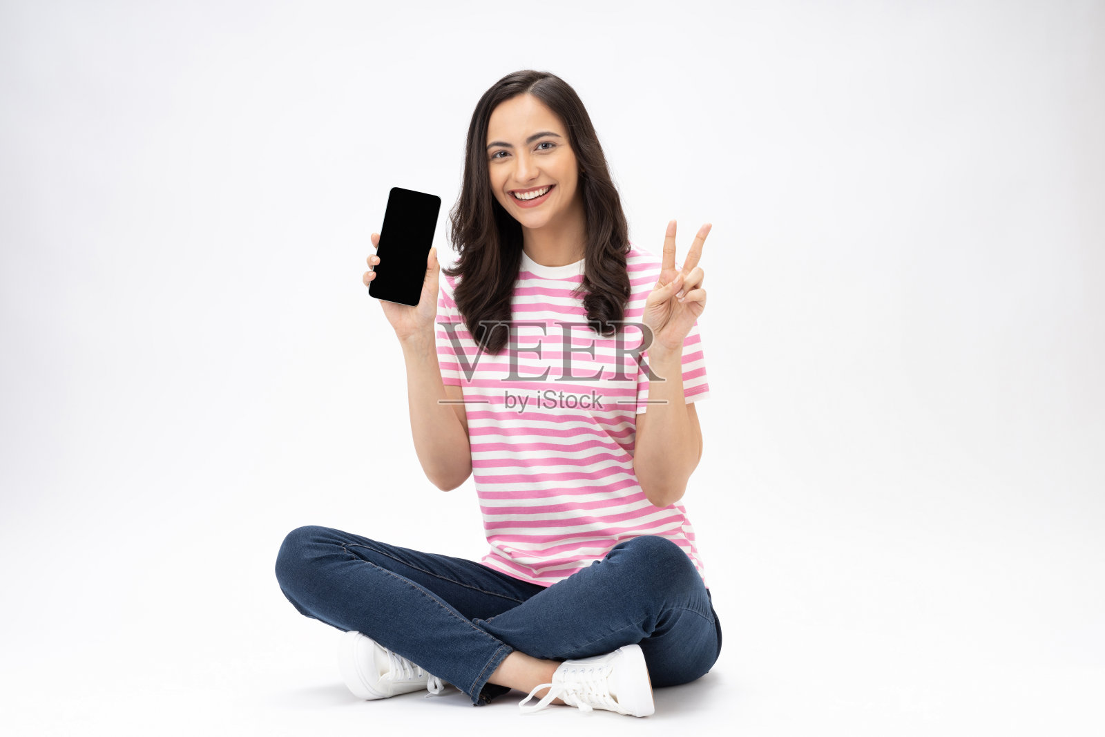 漂亮的年轻女孩的全尺寸照片坐在地板上显示设备屏幕穿时髦的衣服孤立在白色背景的股票照片照片摄影图片