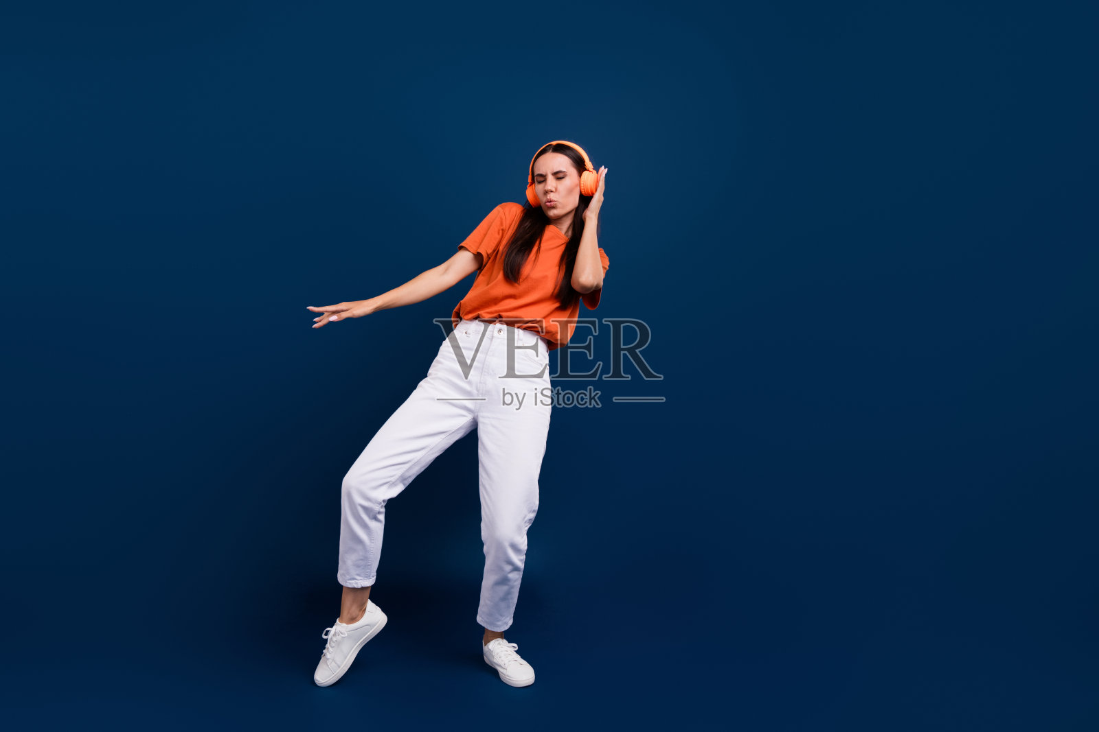 全身照片心情好兴奋的女人穿着橙色t恤耳机享受迪斯科空旷的空间孤立的深蓝色背景照片摄影图片