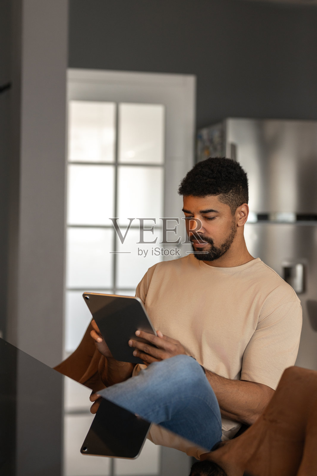 美国人坐在客厅的椅子上，手里拿着平板电脑照片摄影图片