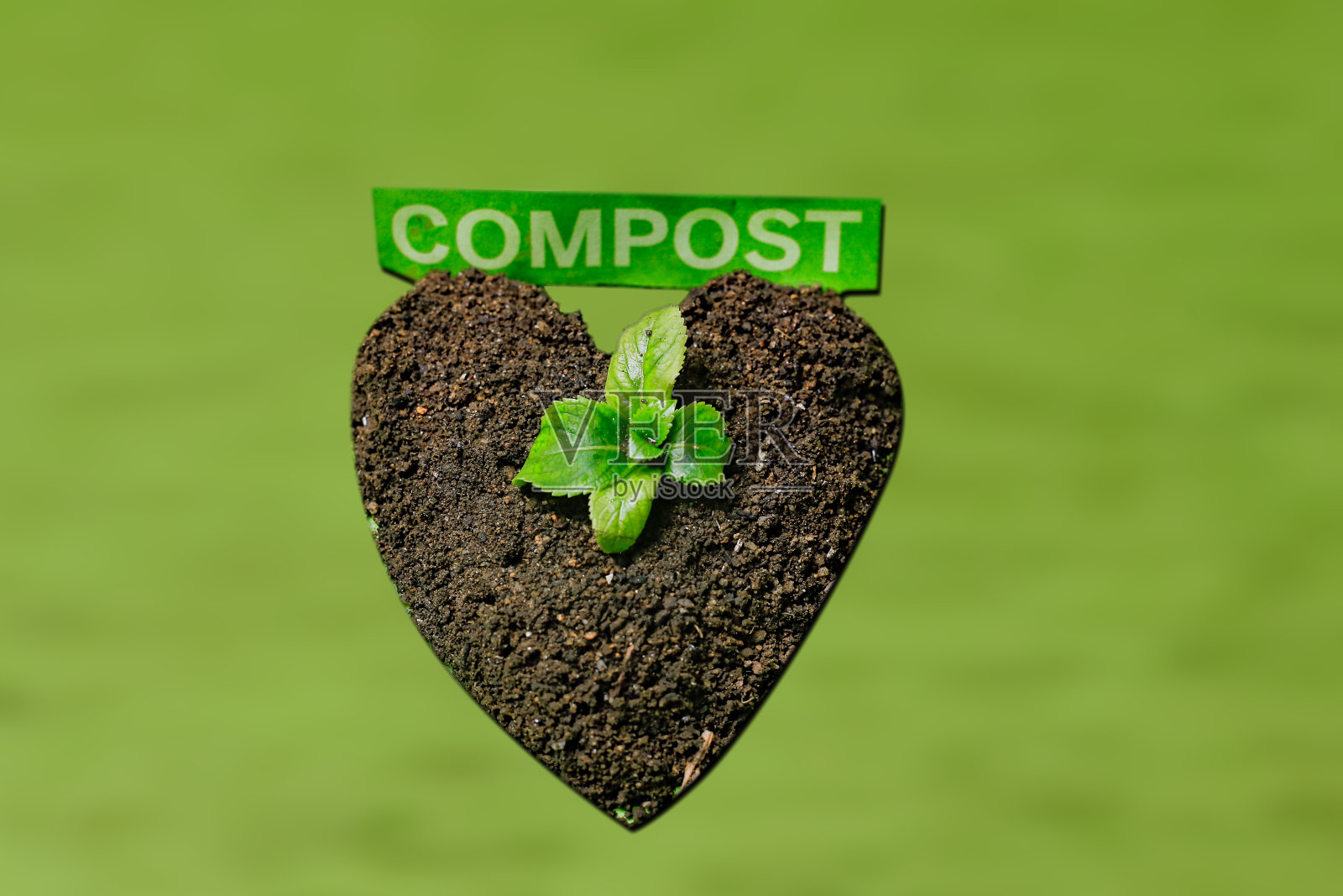 心形的干土和女人的手在白色的木制背景。地球日照片摄影图片