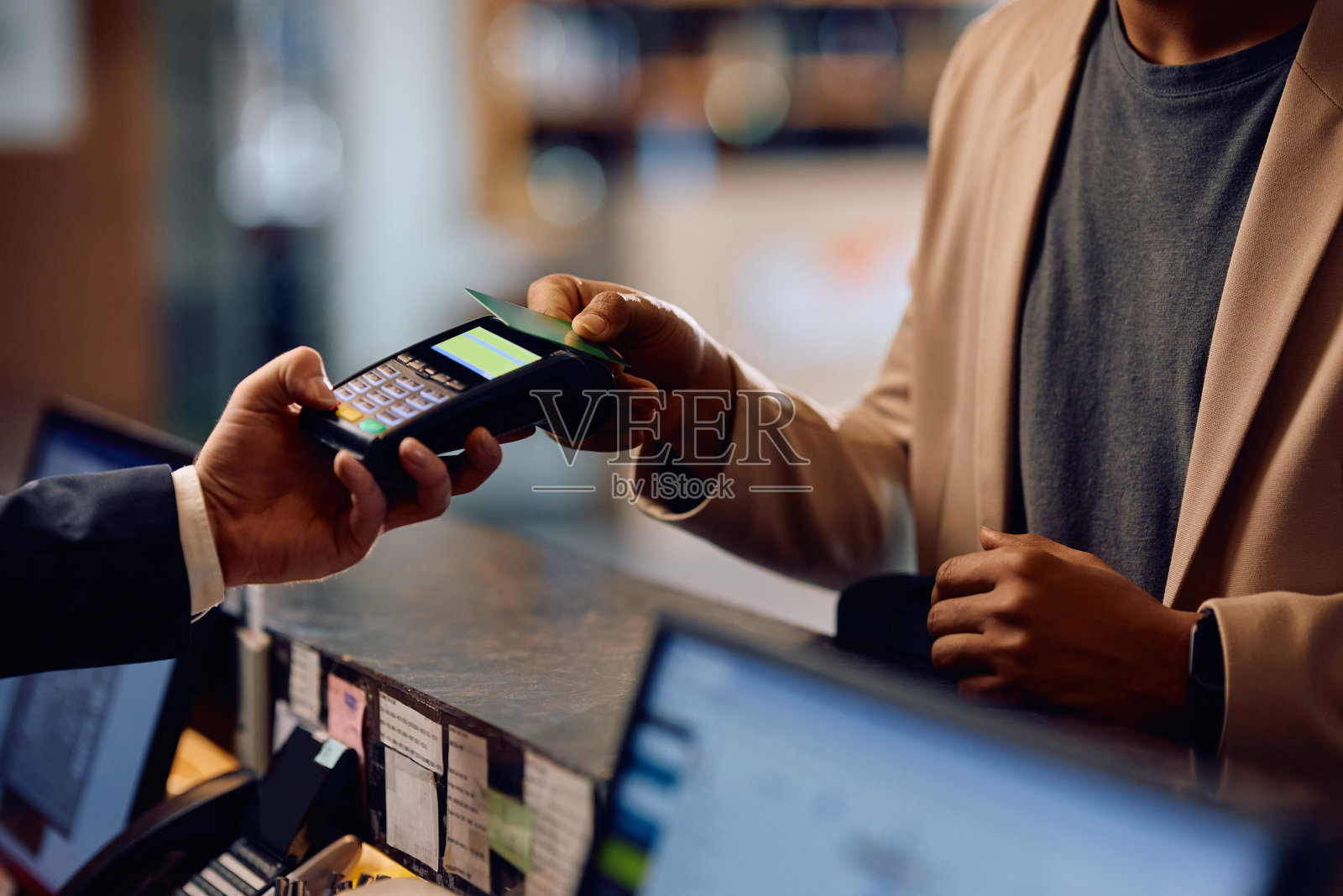 酒店客人用信用卡在前台非接触式付款的特写。照片摄影图片