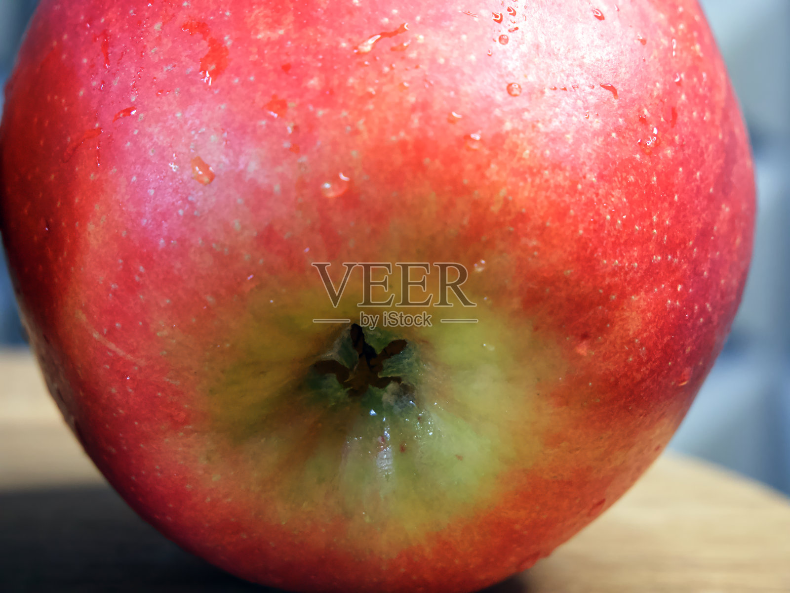 一个大的红苹果在一个木制的表面上，一个特写镜头。照片摄影图片