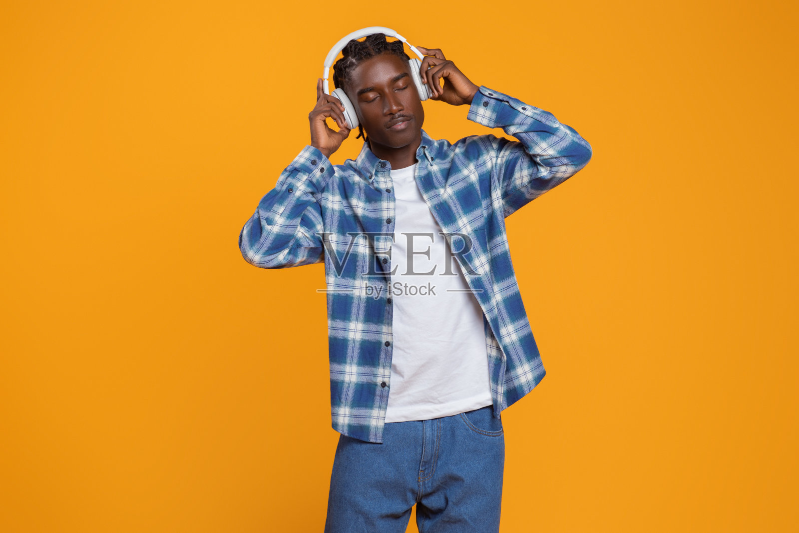 年轻帅气的黑人戴着无线耳机听音乐照片摄影图片