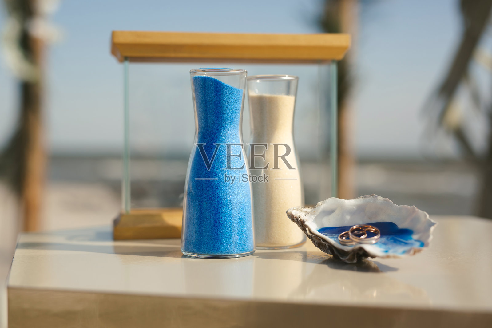 在海洋前的沙滩上，一场象征性的航海风格婚礼上，水晶花瓶里的彩色沙子特写照片摄影图片