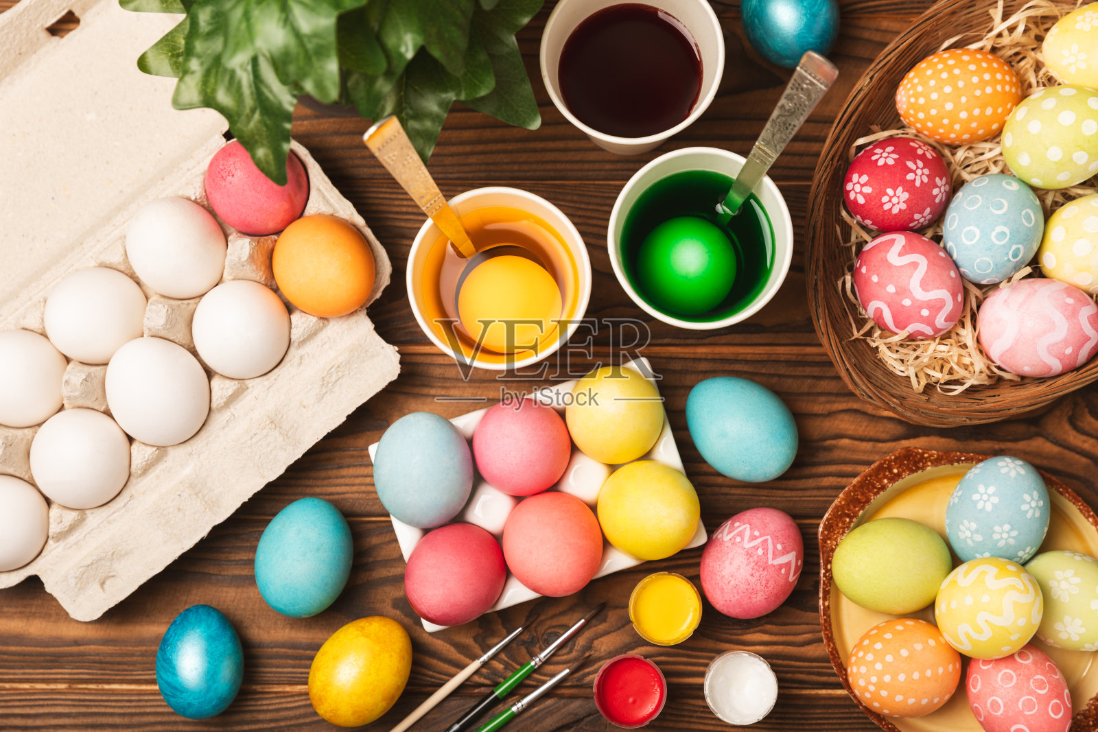 在厨房桌子上画复活节彩蛋。复活节快乐庆祝概念。五颜六色的彩蛋，图案各异。颜料，为节日彩蛋上色的装饰品。创造性的背景。本空间照片摄影图片