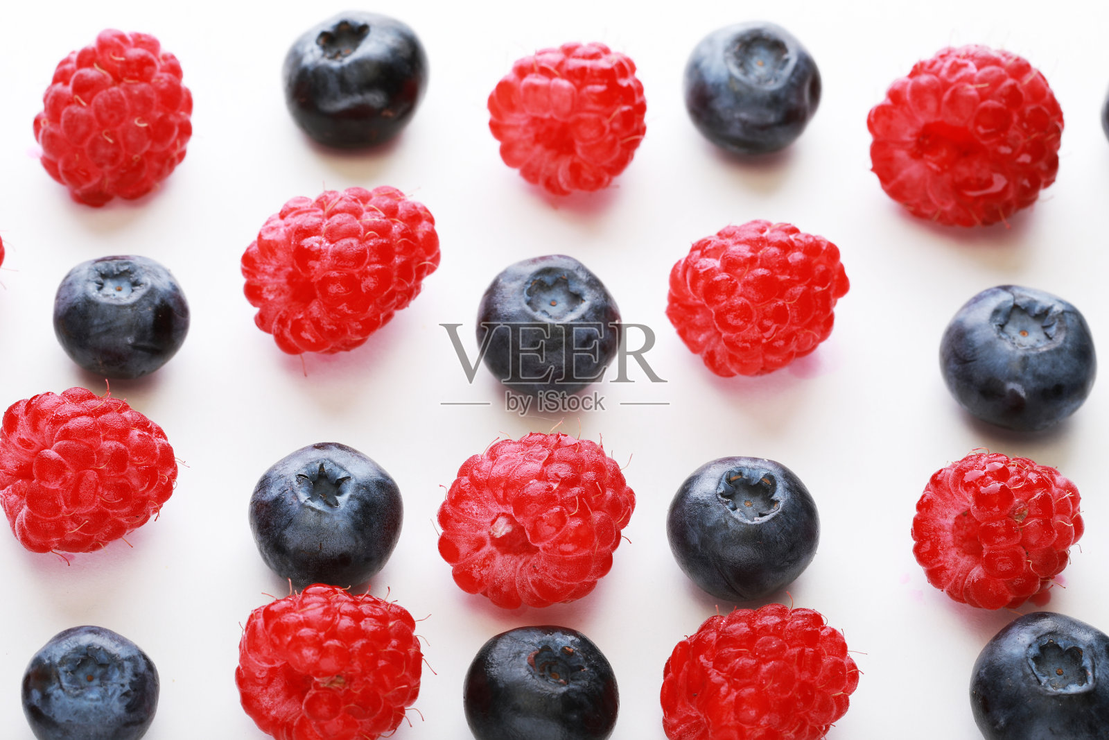 在白色背景上孤立的各种新鲜浆果。树莓和蓝莓照片摄影图片