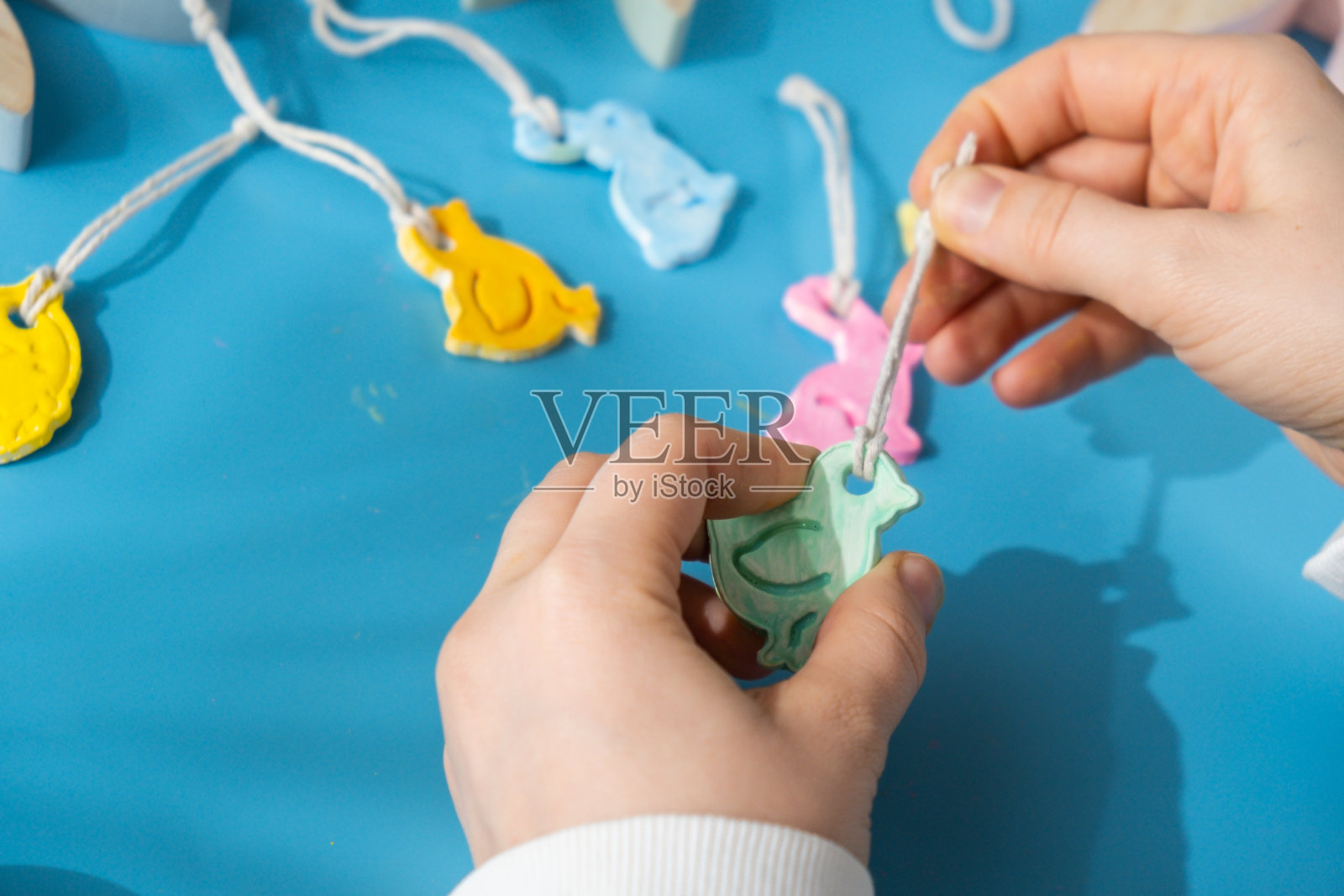 不可识别的艺术家自己做，风干粘土工艺品为复活节假期。装饰礼物的想法手工儿童工艺品。按部就班地指导绘画、压图照片摄影图片