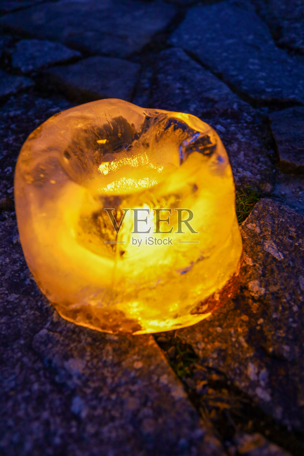 在冬天夜晚照亮道路的冰灯。照片摄影图片