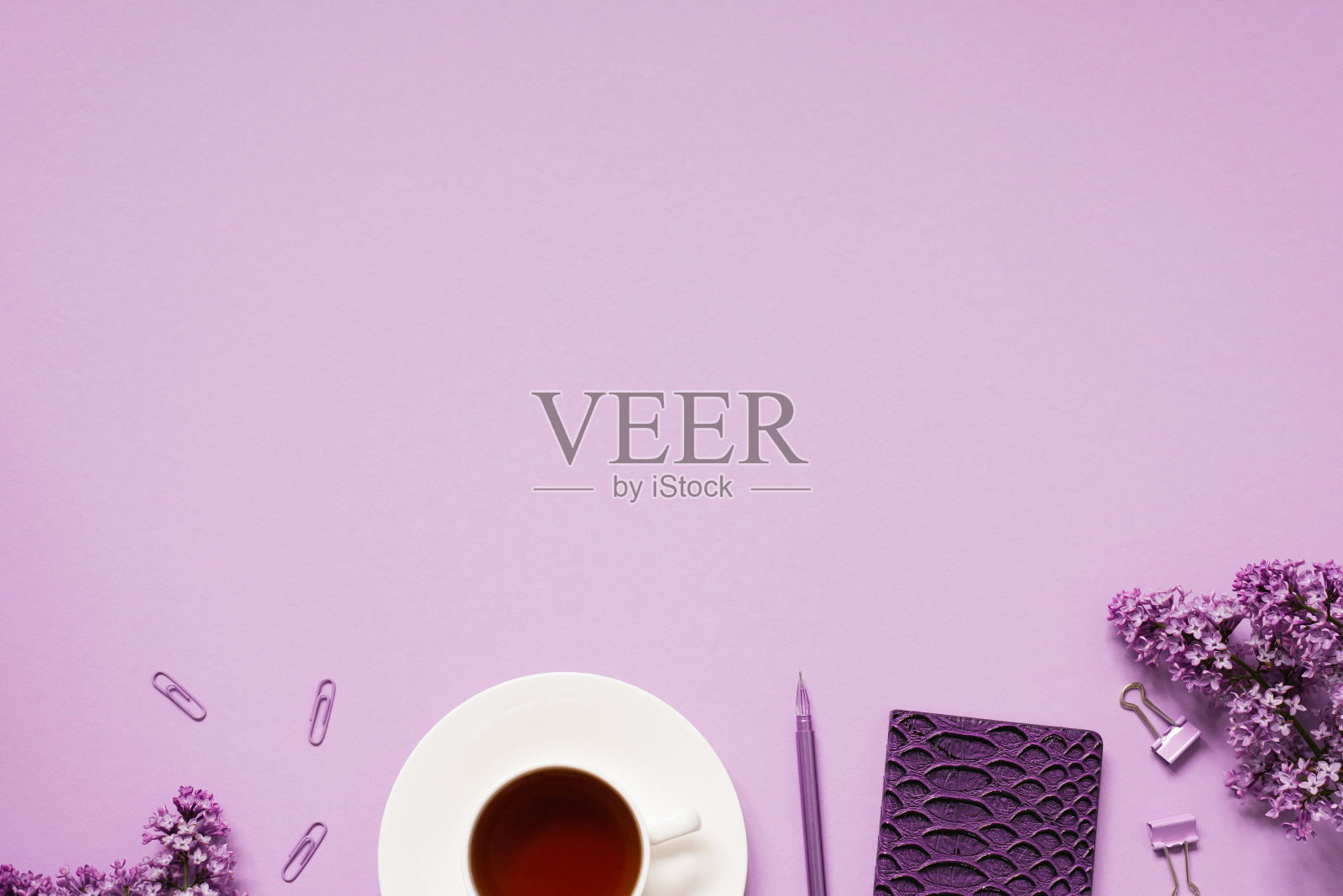 博客或办公室职员的工作空间。记事本，笔，电话，回形针，丁香花。茶歇时间照片摄影图片