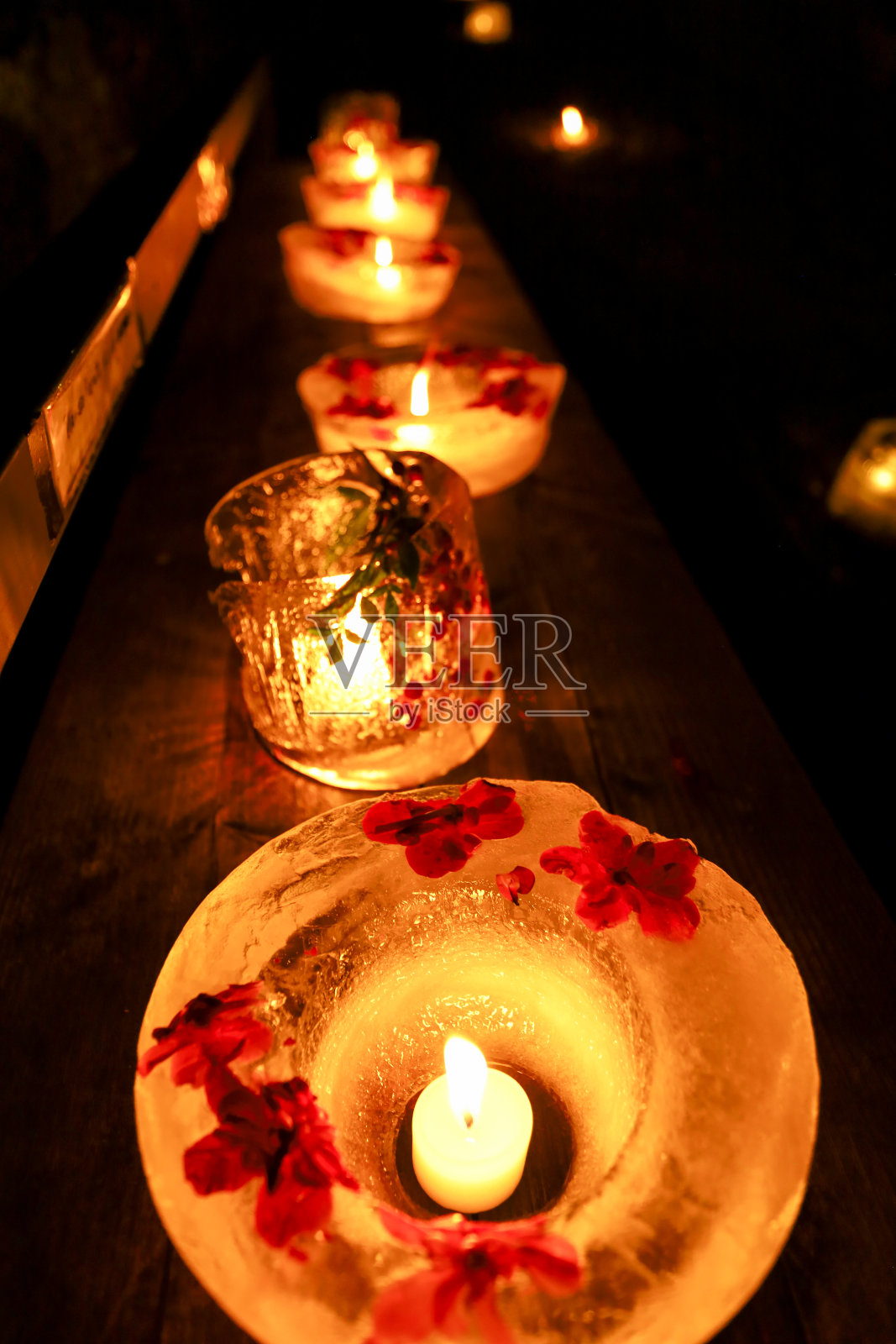 在冬天夜晚照亮道路的冰灯。照片摄影图片