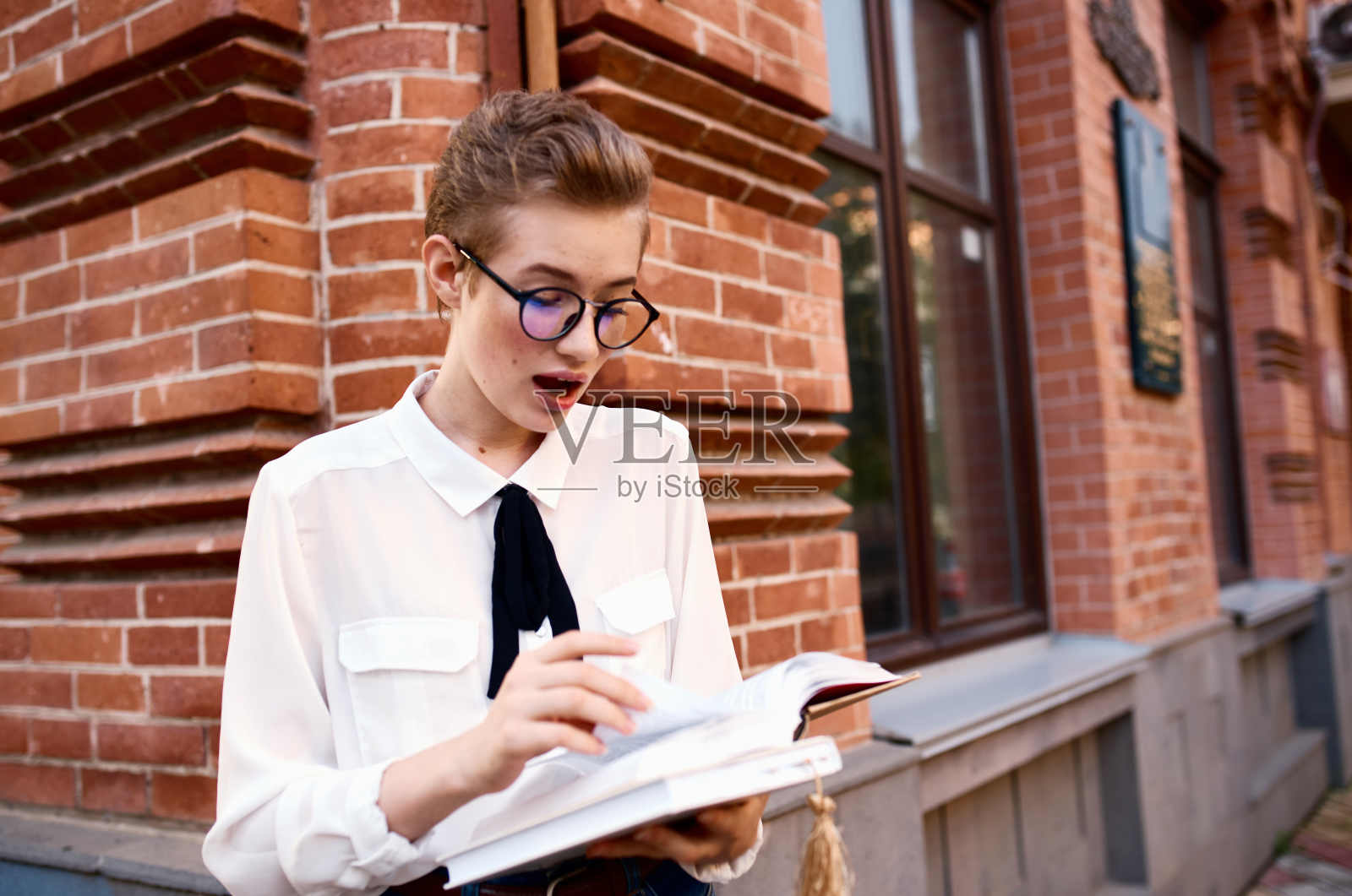 短头发的女人在大厦附近的街道休息生活方式照片摄影图片