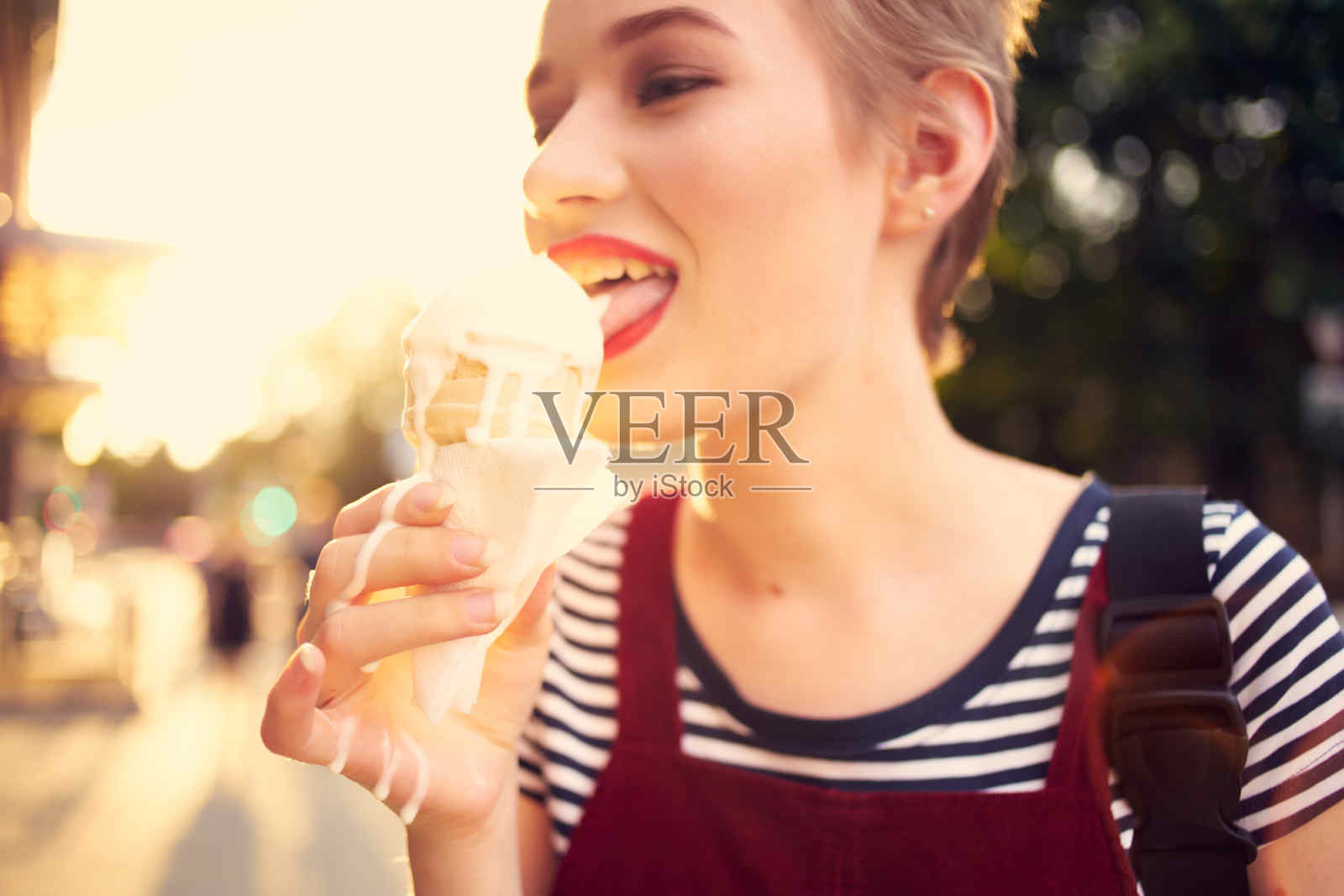 短发女人在户外吃冰淇淋走路的生活方式照片摄影图片