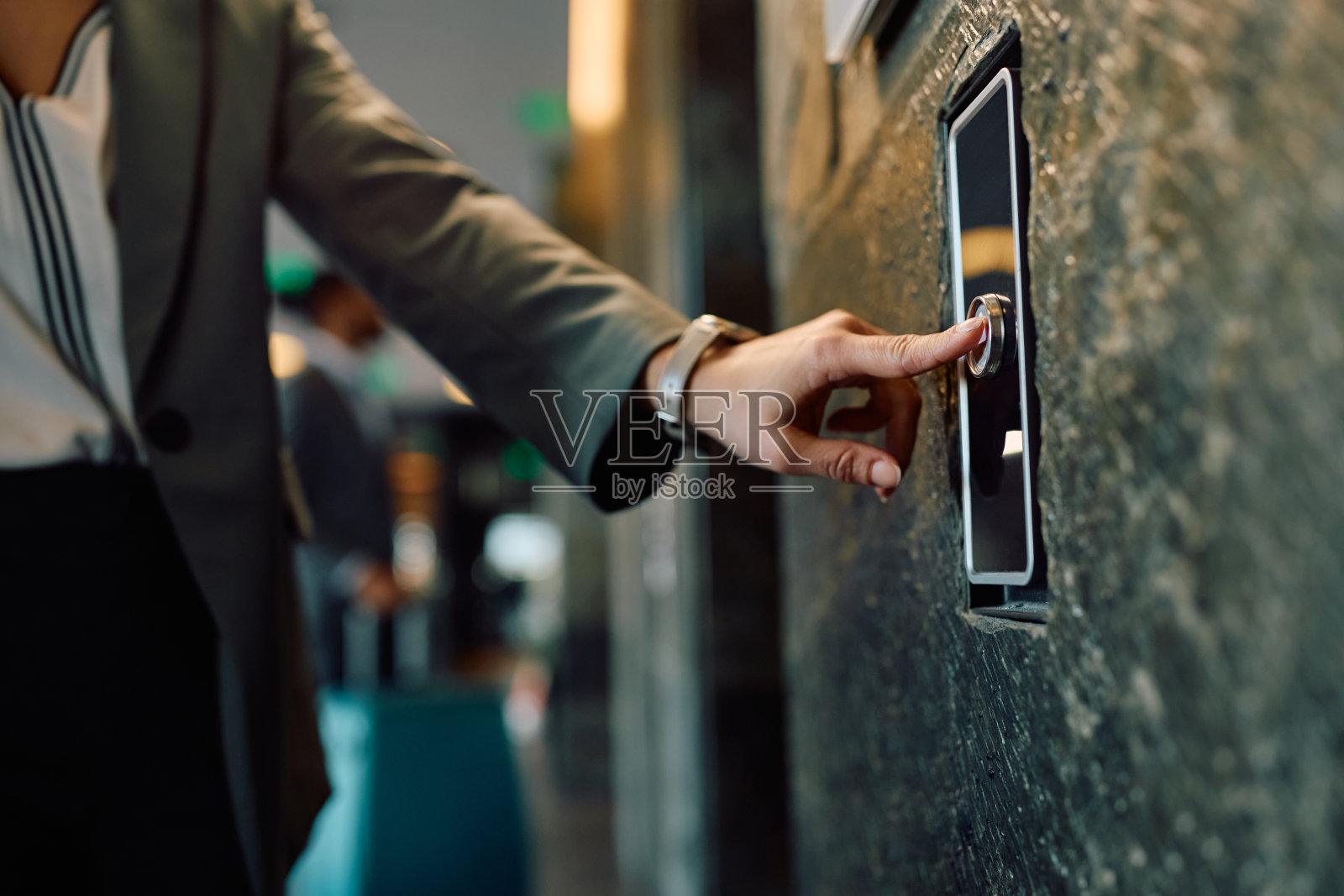 女商人在酒店大堂按电梯按钮的特写。照片摄影图片