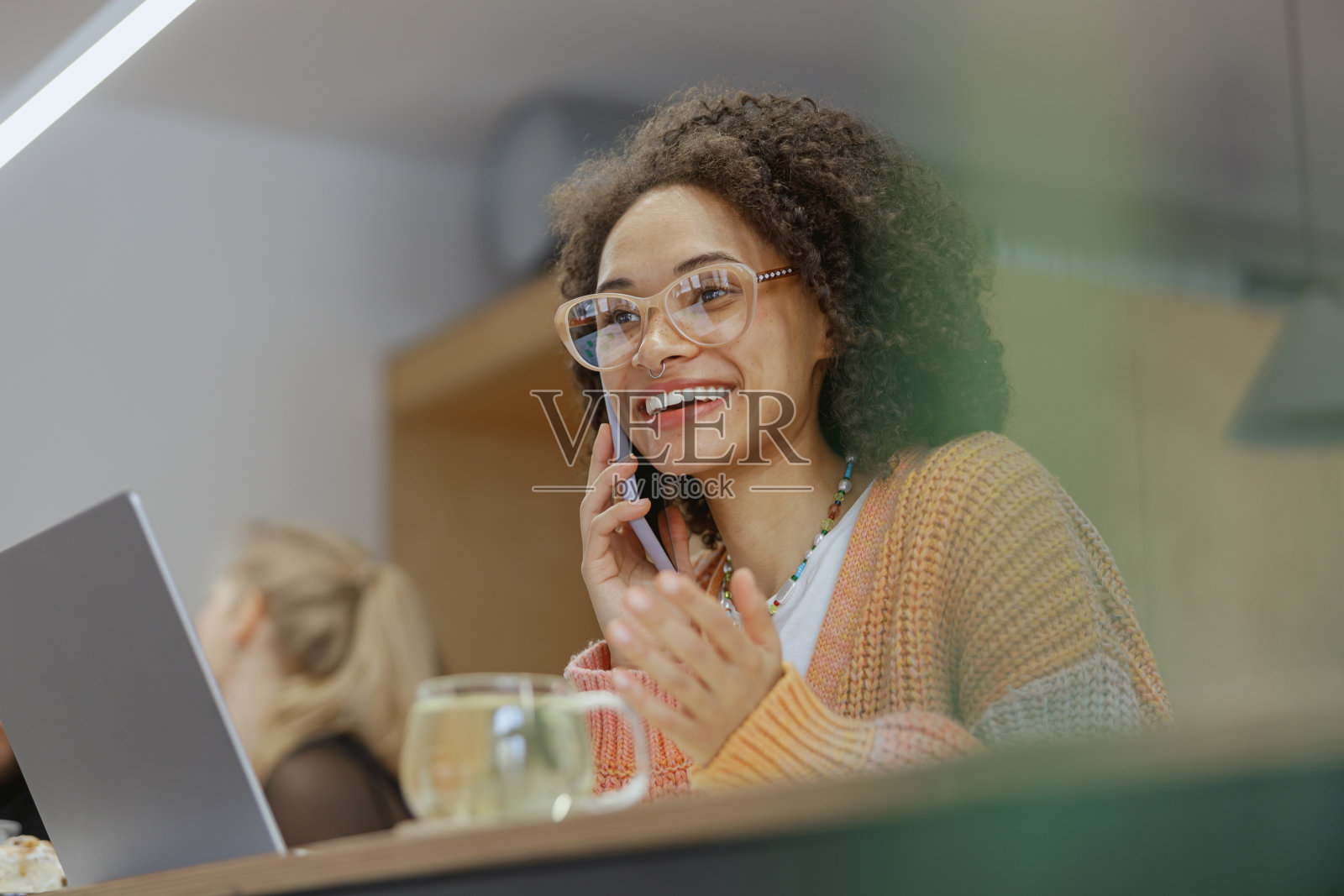 一个自由职业的女人正坐在桌旁用手机聊天照片摄影图片
