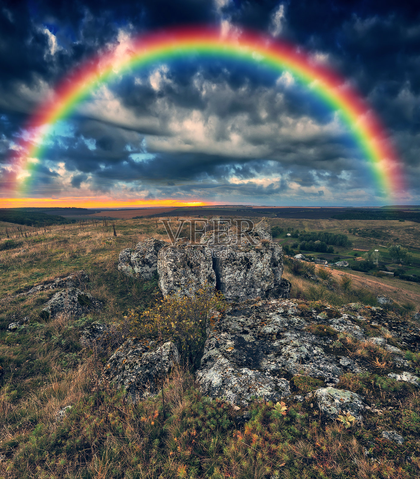 彩虹和云彩在一块岩石上。乌克兰的性质照片摄影图片