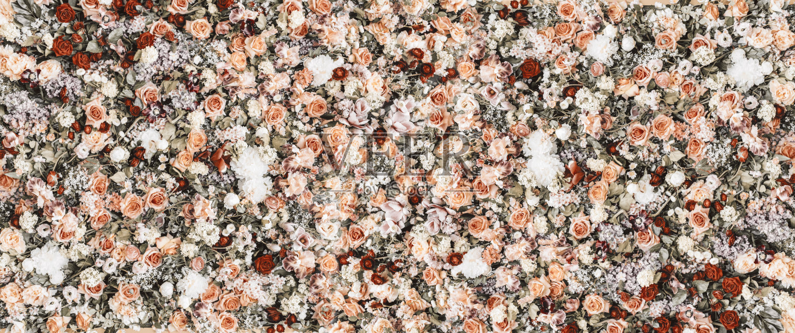 美丽的花墙背景与新鲜的玫瑰和花束图案。复古的婚礼装饰横幅。照片摄影图片