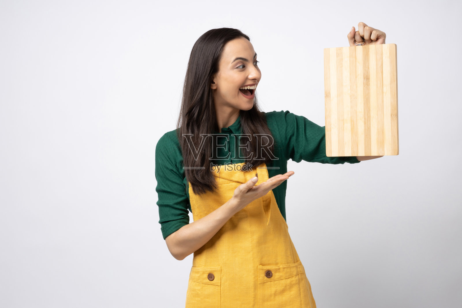 印度女厨师戴着围裙，拿着砧板，独自站在白色背景的股票照片照片摄影图片