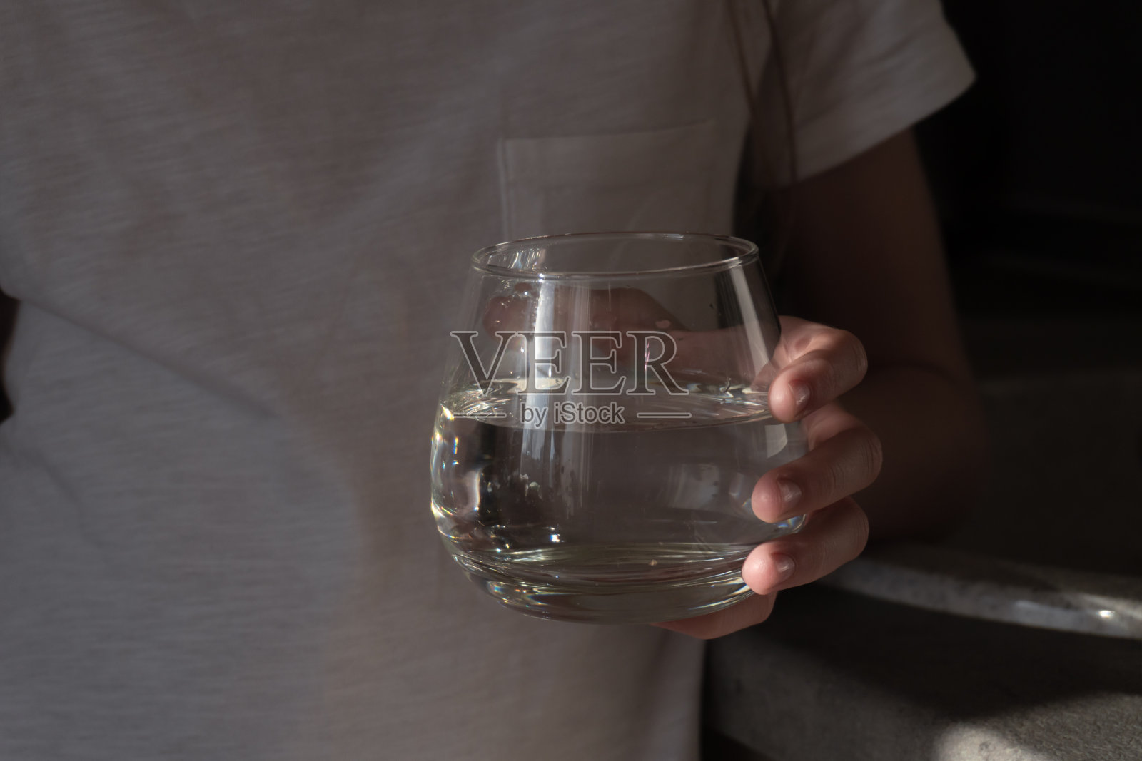 孩子手中的一杯干净的水照片摄影图片