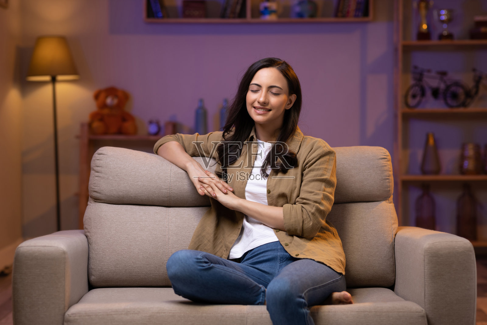 年轻女子坐在客厅舒适的沙发上放松照片摄影图片