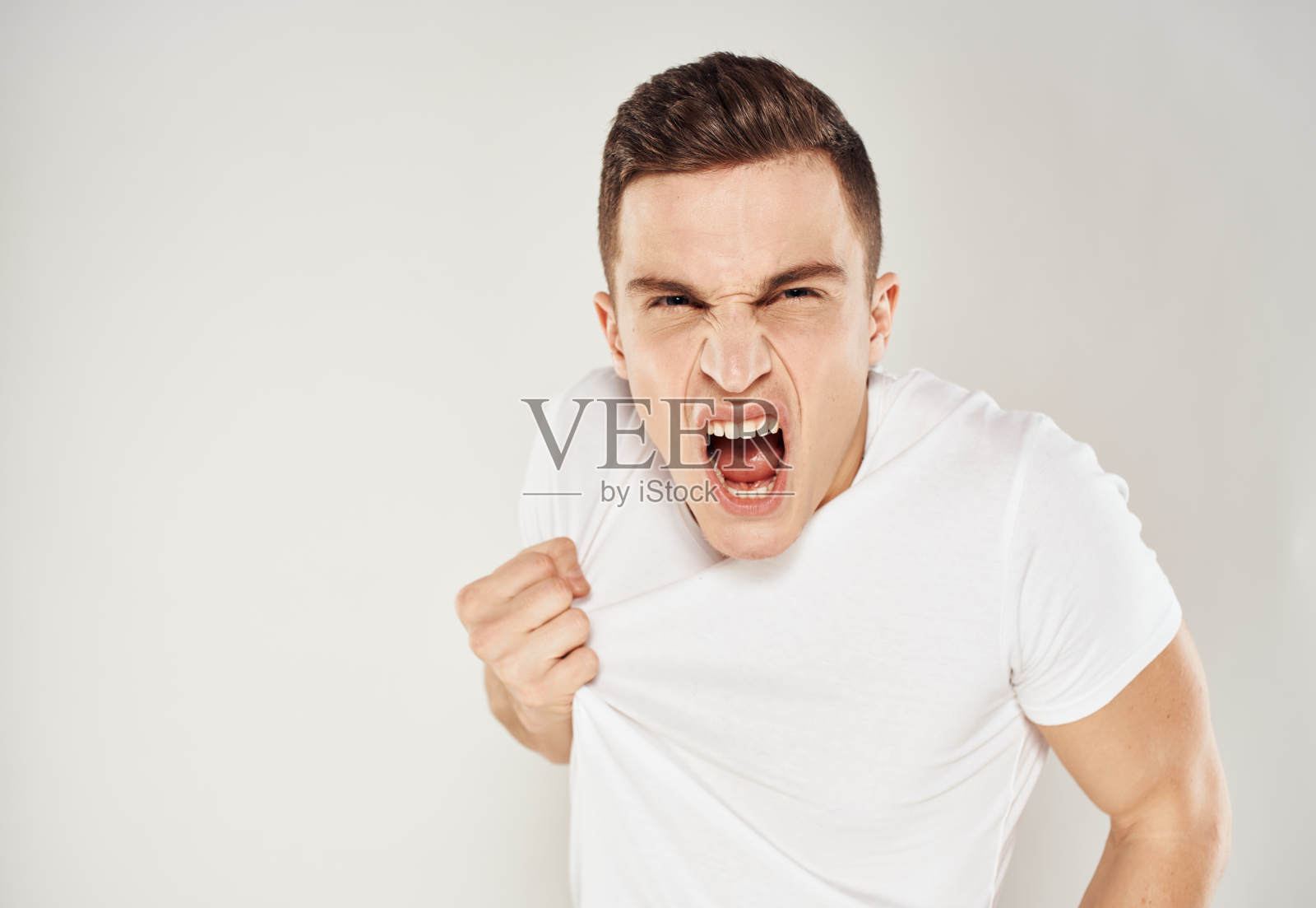 疯子用手在浅色背景上做手势尖叫，紧张烦躁照片摄影图片