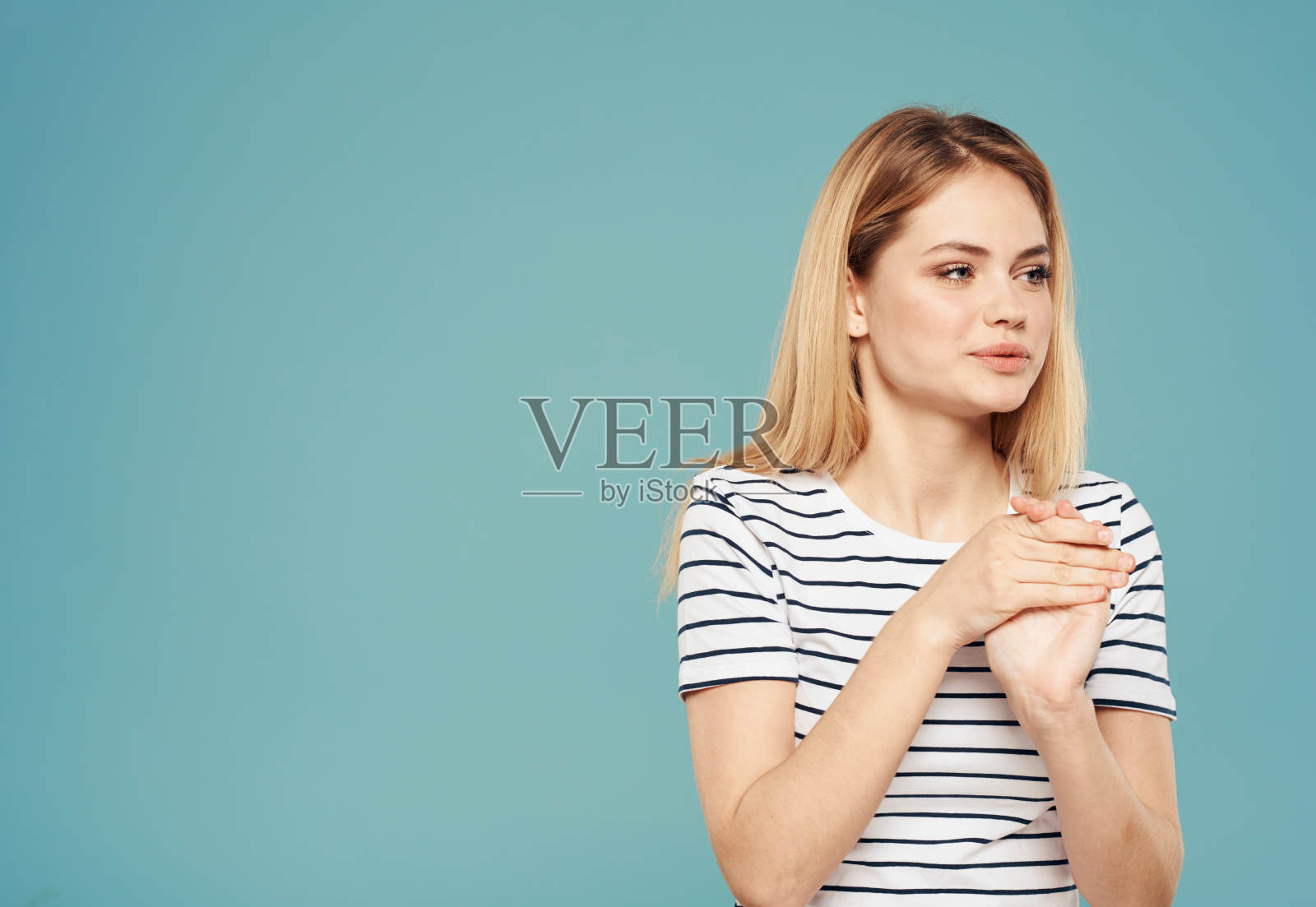 可爱的金发女郎的肖像在条纹t恤上的蓝色背景复制空间照片摄影图片