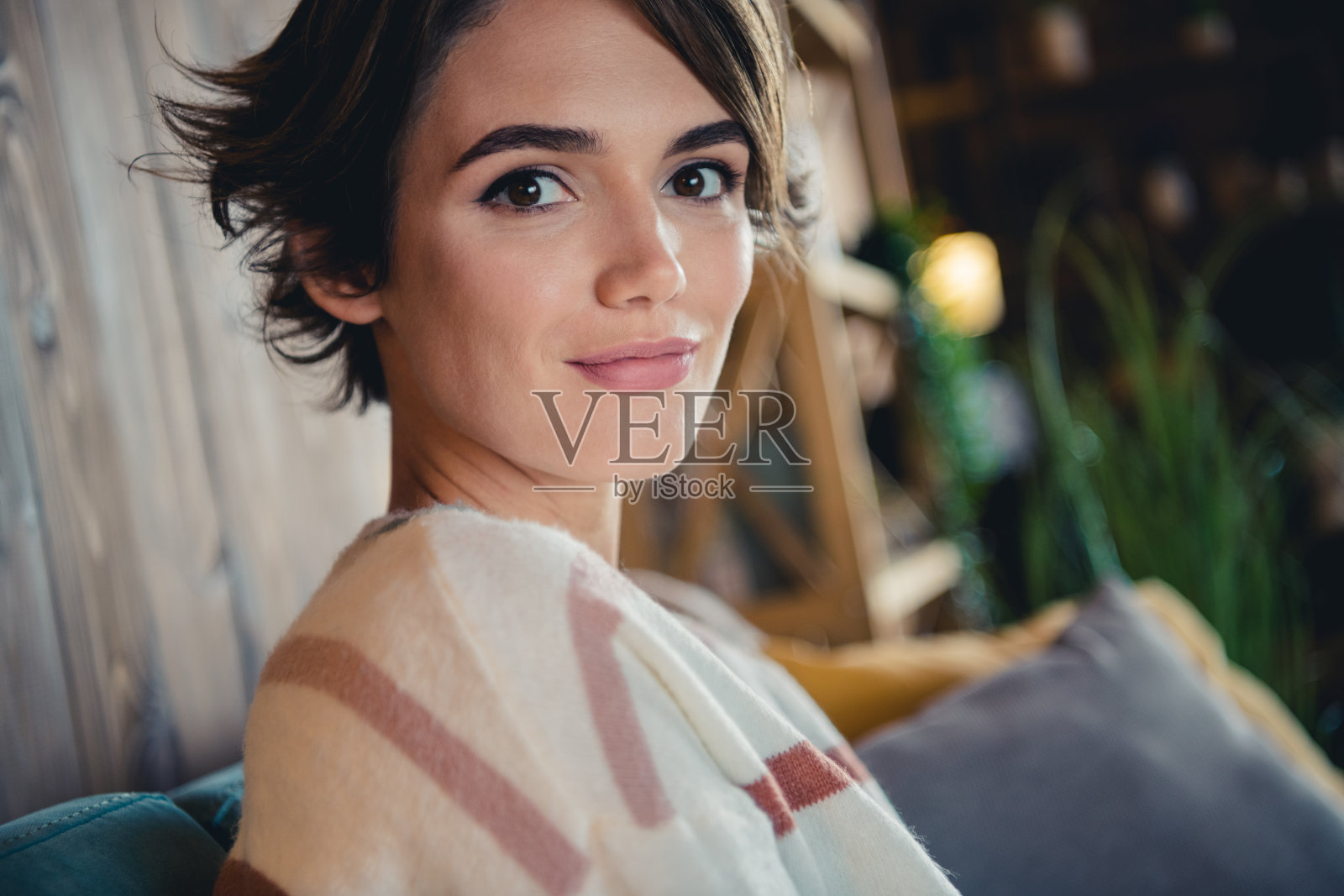 近距离剪裁的令人惊叹的满意的年轻人的侧面肖像坐在沙发上消遣宁静的公寓里面照片摄影图片