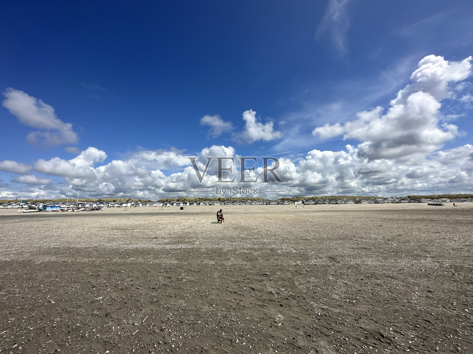 一个人在阴天走在沙滩上照片摄影图片